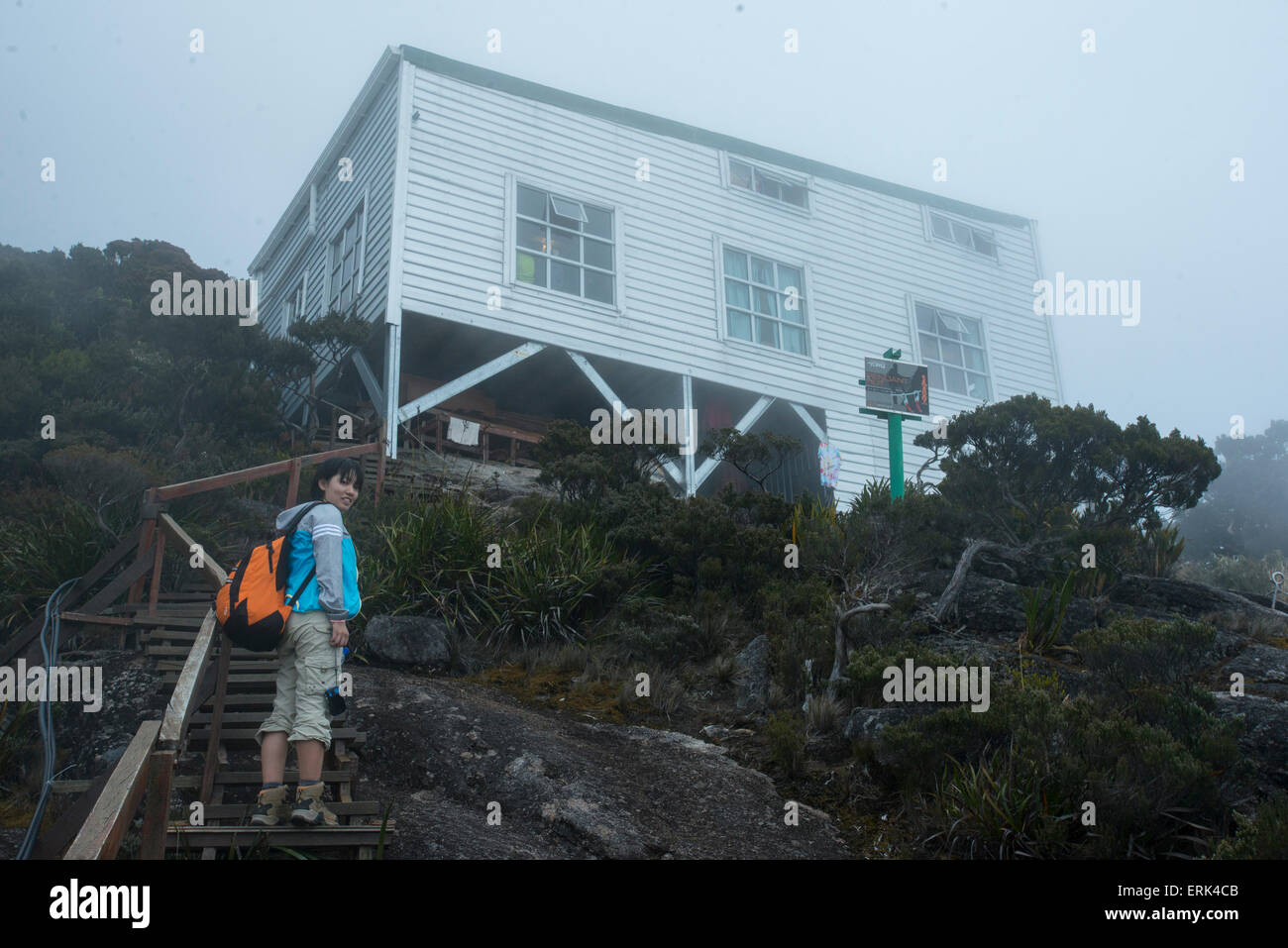 Girl poses at stairs with Pendant Hut in the brackground, Mount Kinabalu, Sabah, Borneo, Malaysia Stock Photo