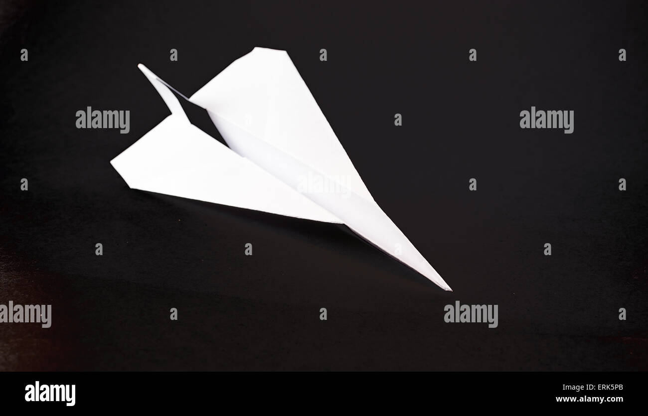 Solitary white paper airplane in flight on a black background Stock ...
