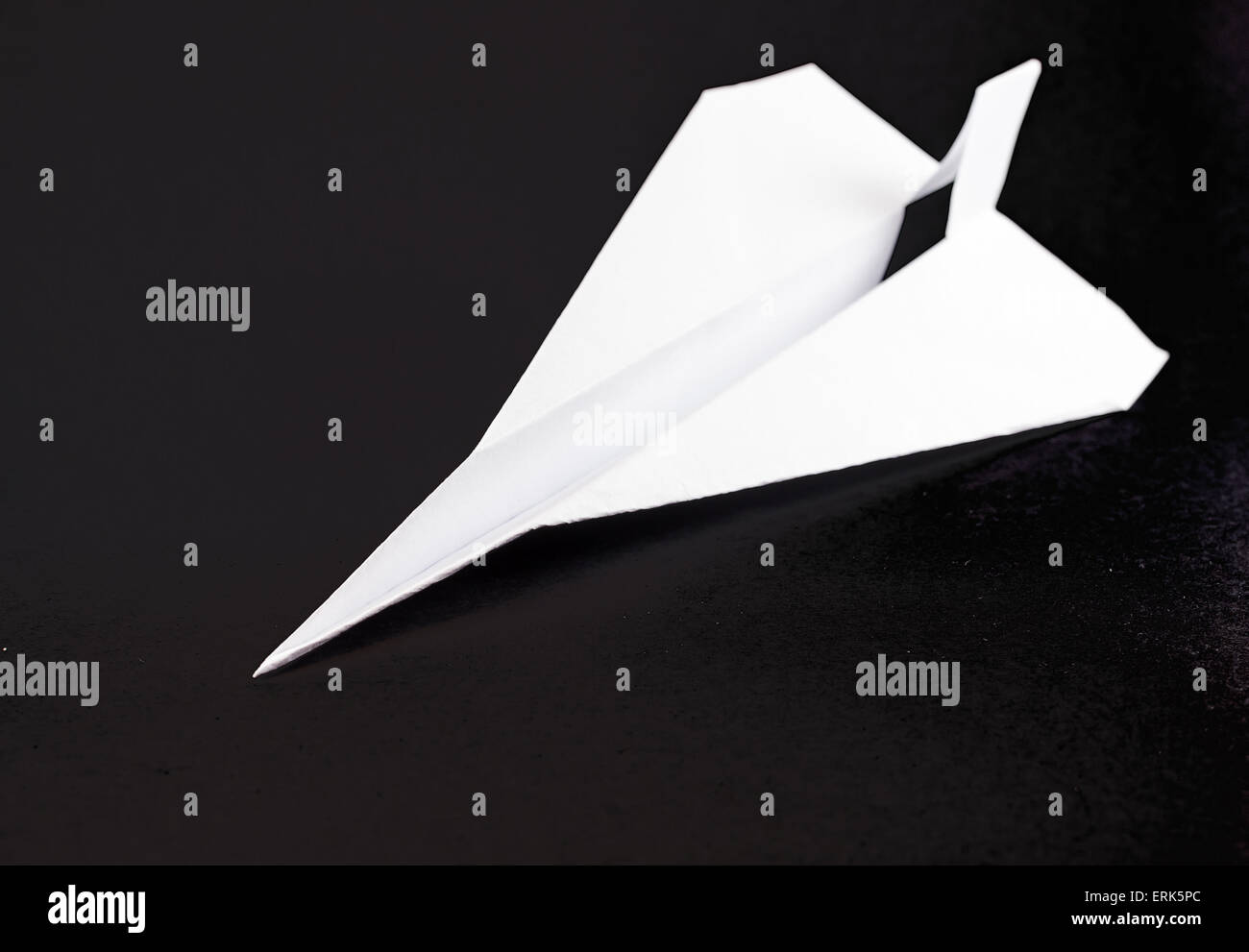 Solitary white paper airplane in flight on a black background Stock ...