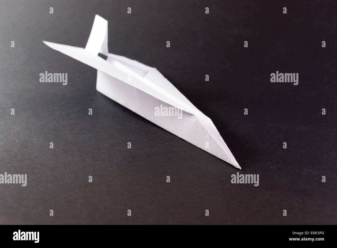 Solitary white paper airplane in flight on a black background Stock ...