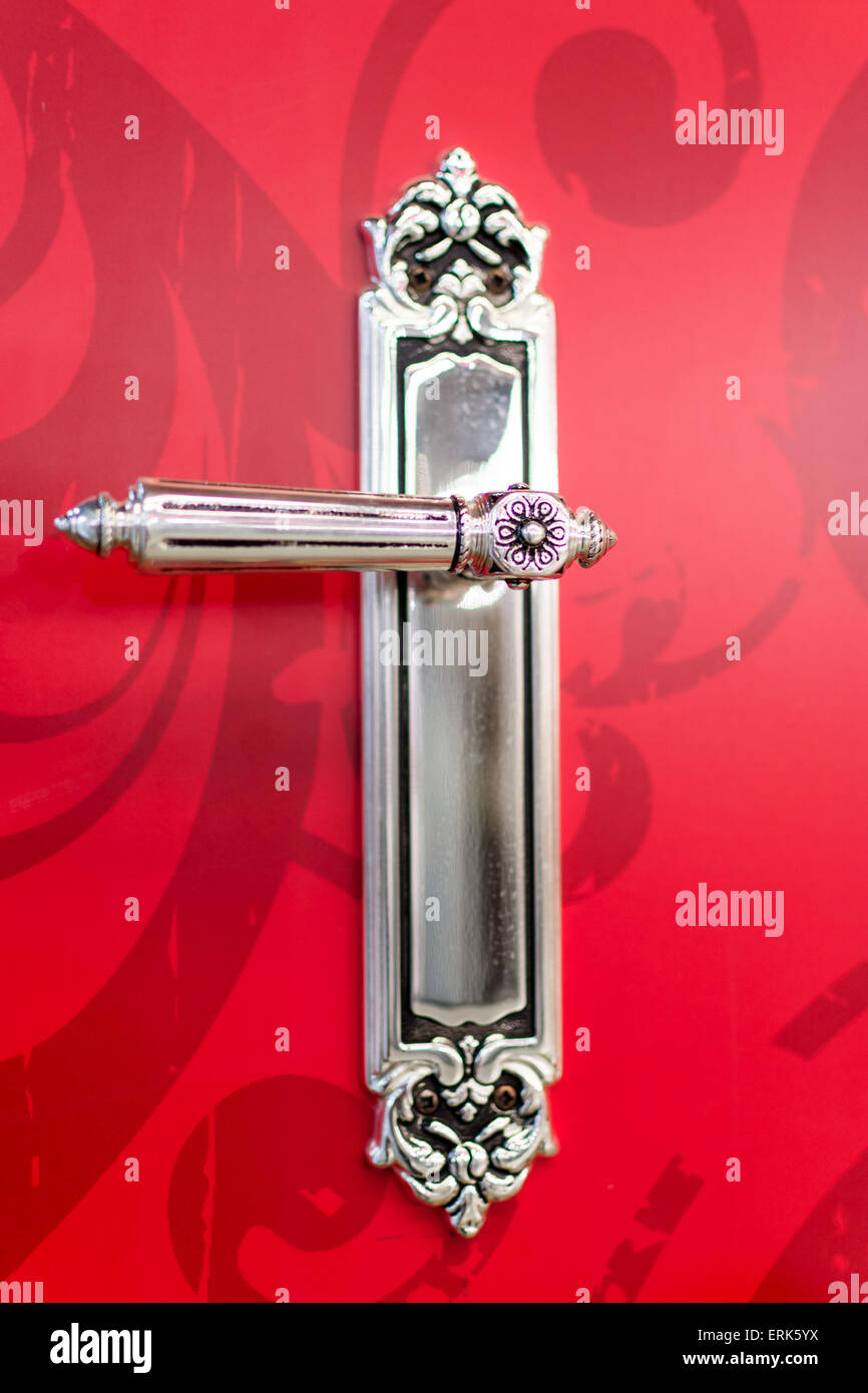 Antique chrome door handle on a red design background Stock Photo