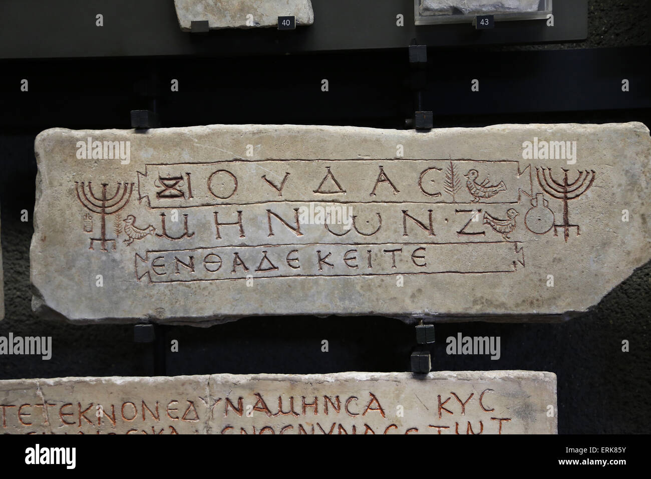 Early Christian. Stone slab that closed the burial niche of a baby. Hebrew symbols and the Greek inscription. Stock Photo