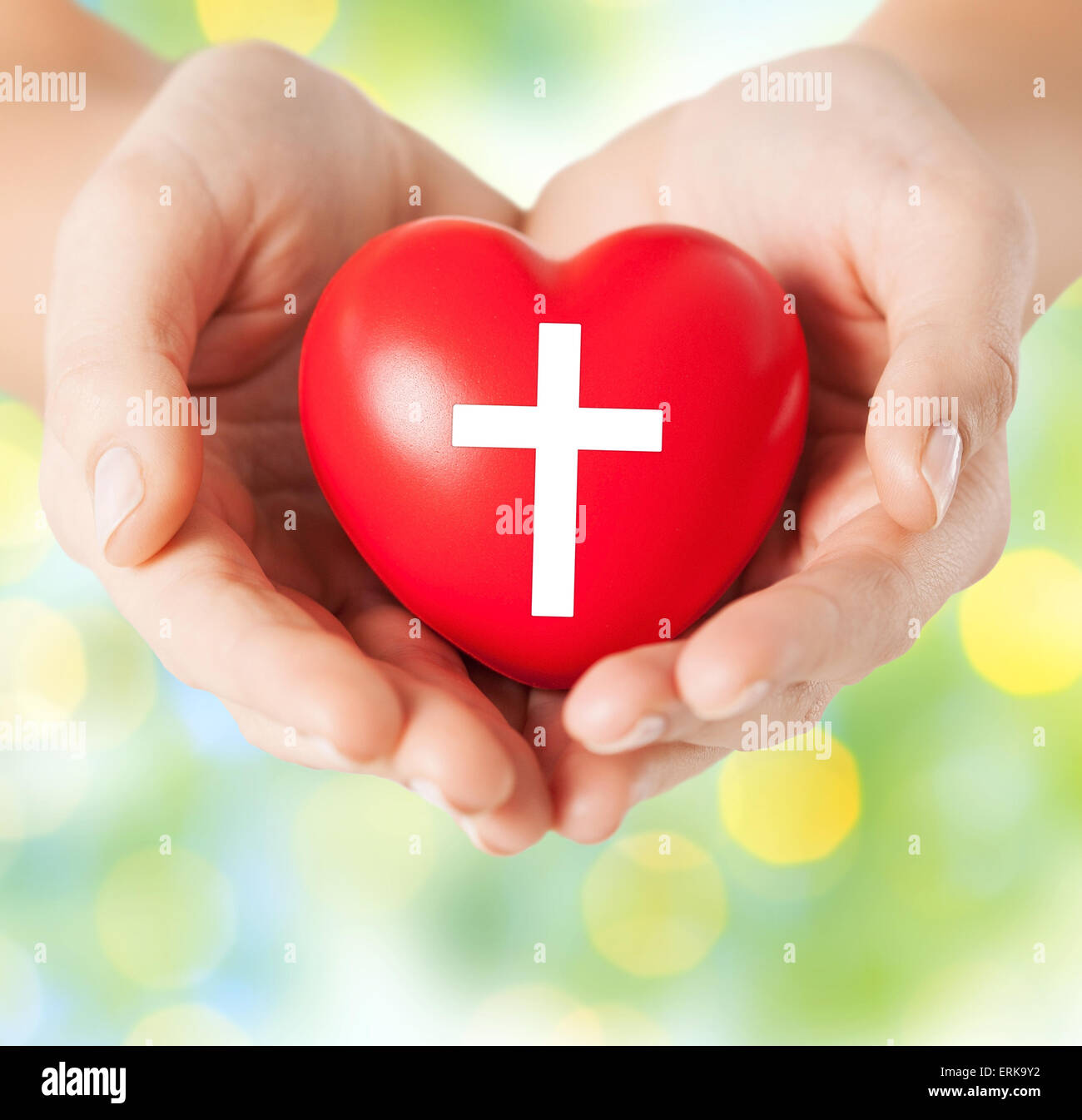 close up of hands holding heart with cross symbol Stock Photo - Alamy