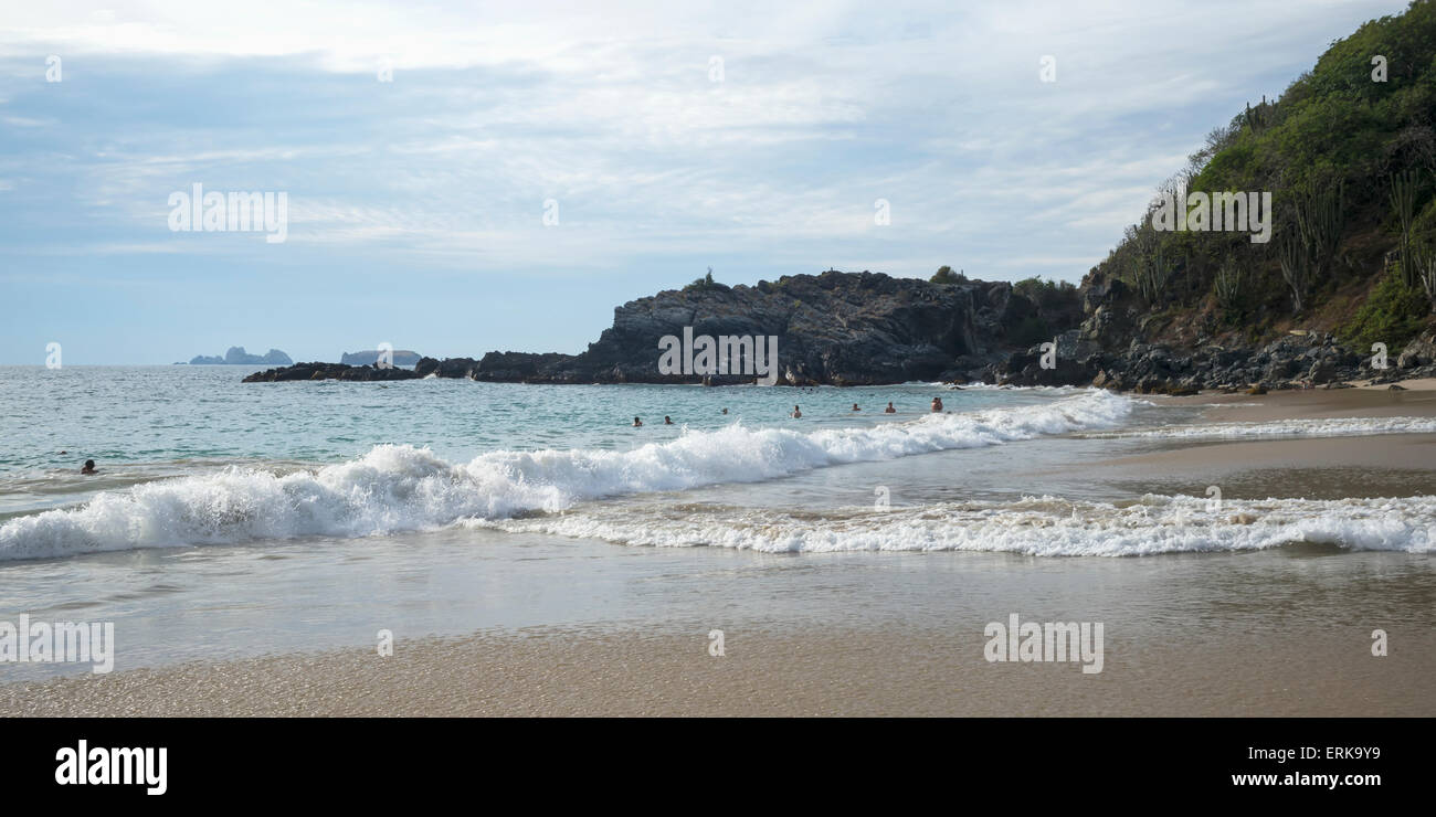 Waves crash into the beach and swimmers in the water; Guerrero, Mexico Stock Photo