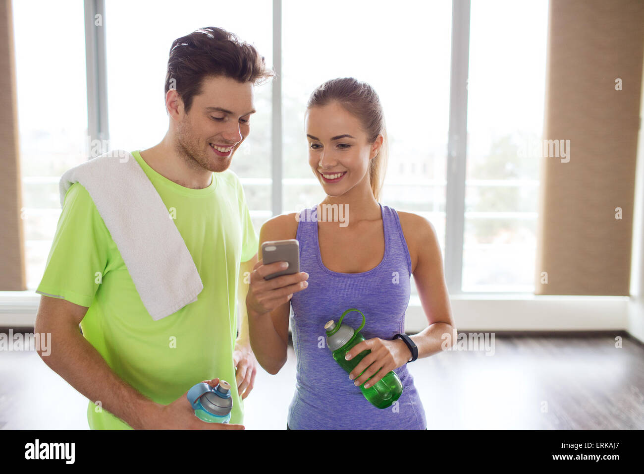 happy woman and trainer showing smartphone in gym Stock Photo - Alamy