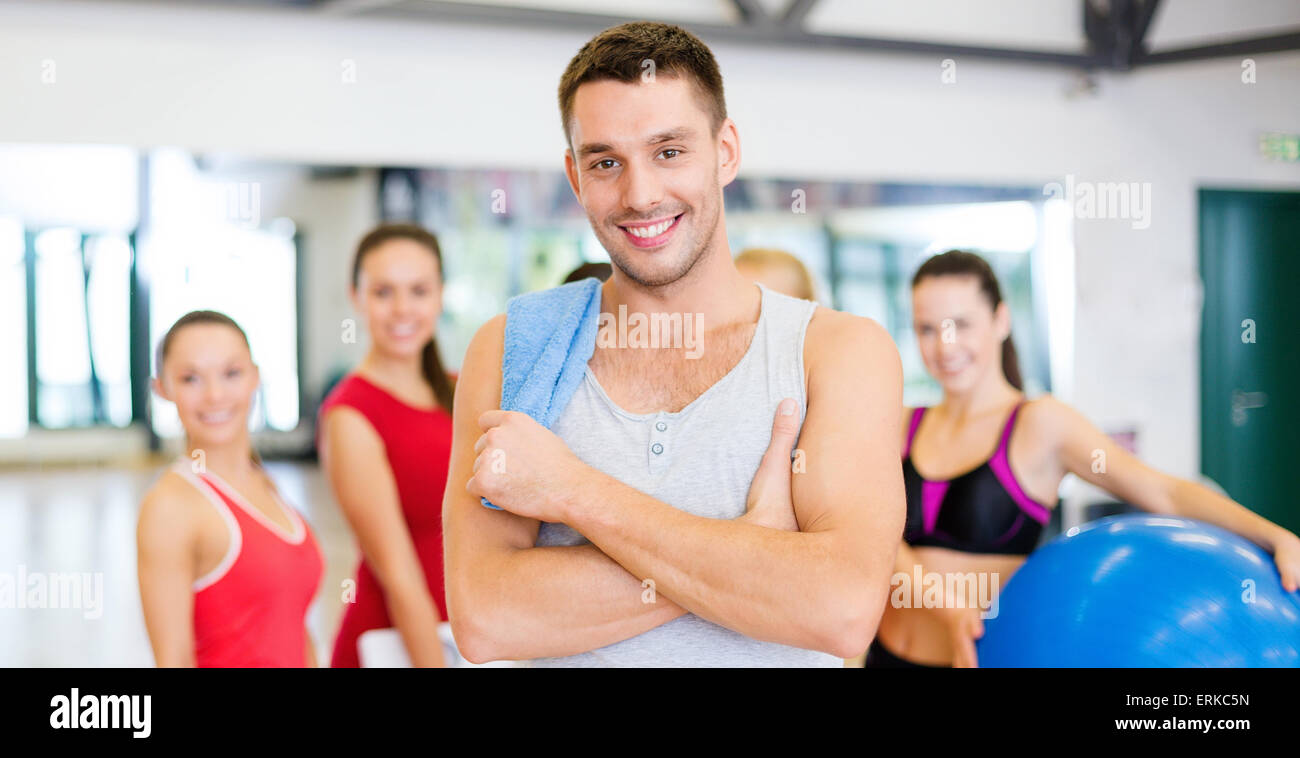 smiling man standing in front of the group in gym Stock Photo - Alamy