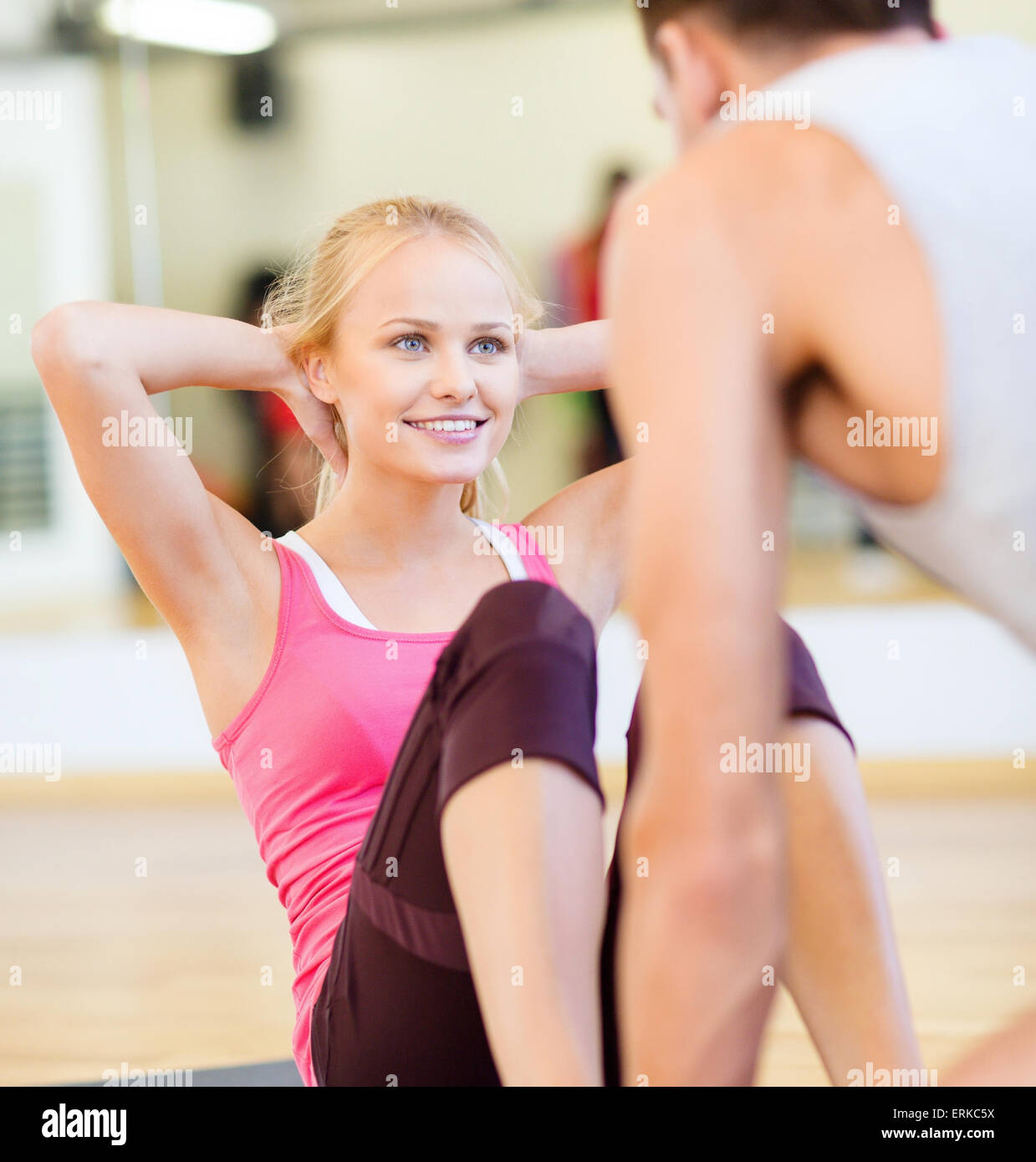 male trainer with woman doing sit ups in the gym Stock Photo