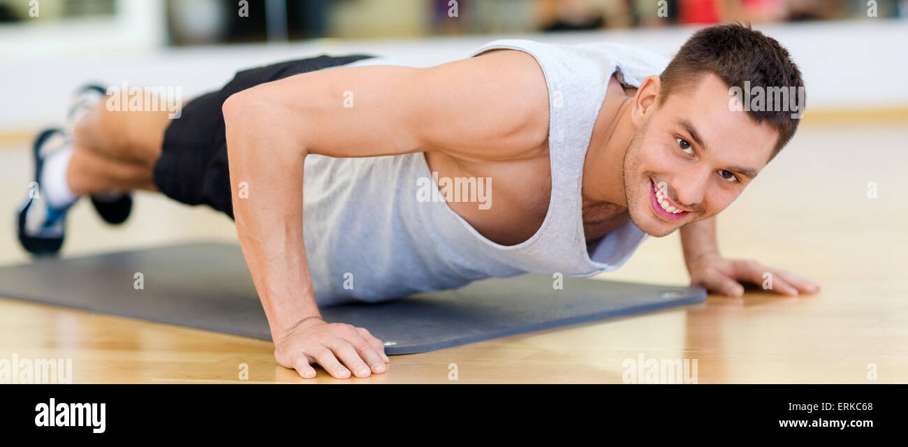 smiling man doing push-ups in the gym Stock Photo