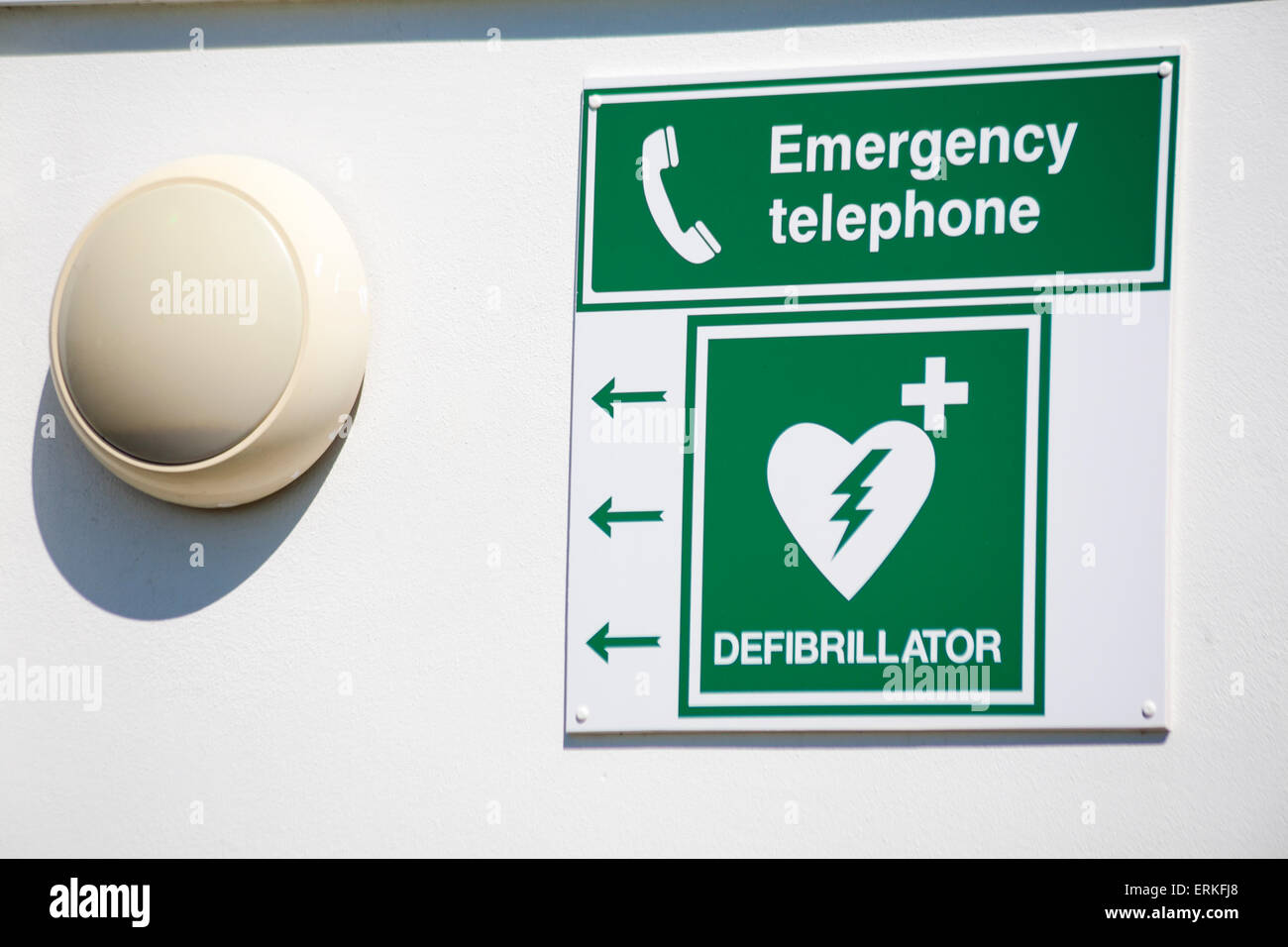 Emergency telephone and defibrillator signs on wall at freshwater bay