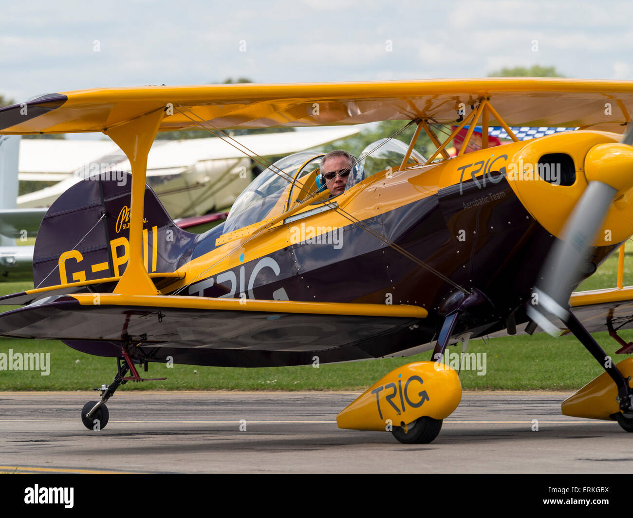 the pilot of a Pitts Special aerobatic biplane looks out of the cockpit,at Aerexpo 2015 aviation event,at Sywell airfield,Northa Stock Photo