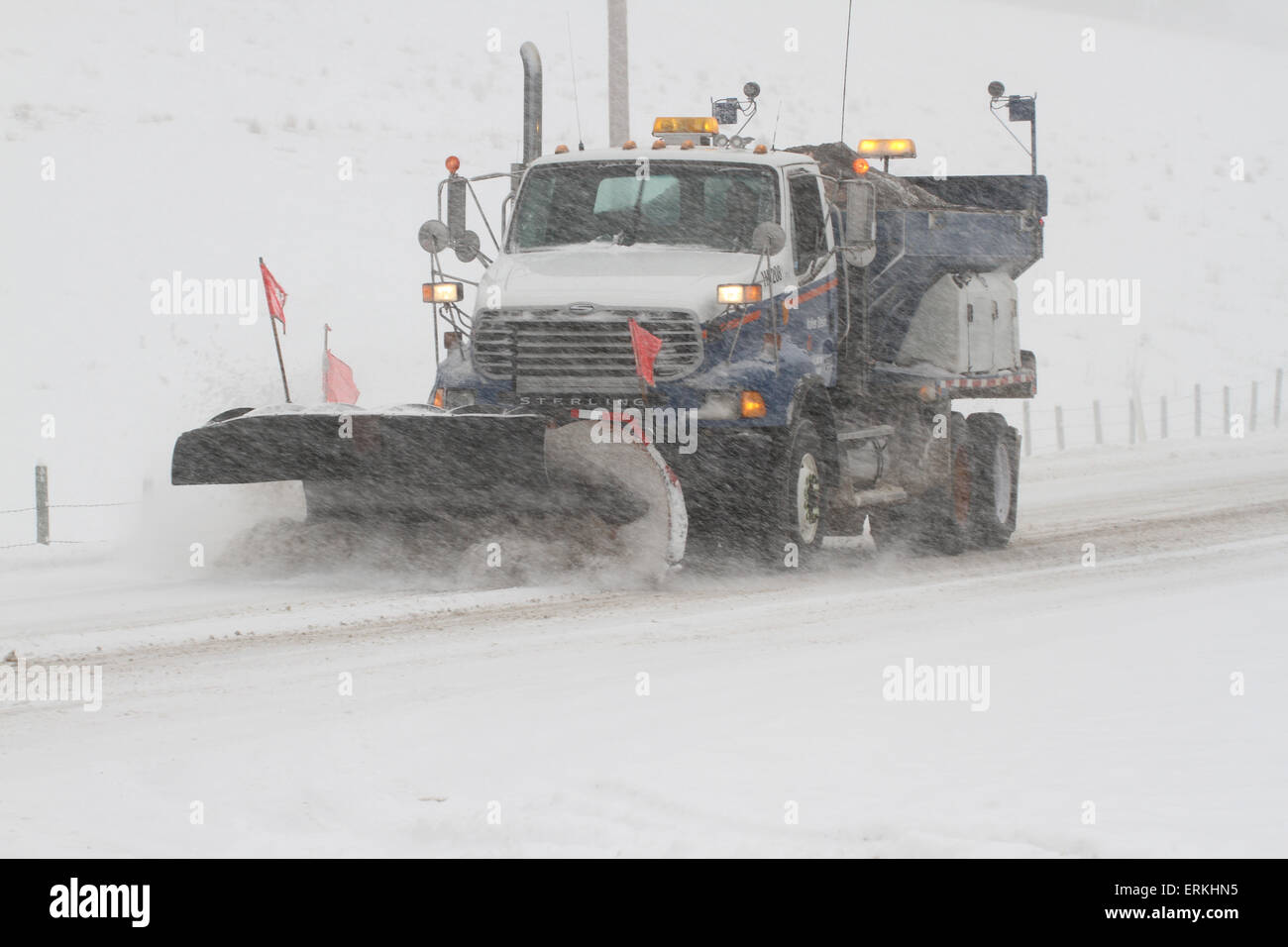 Snow plow clearing a road Stock Photo