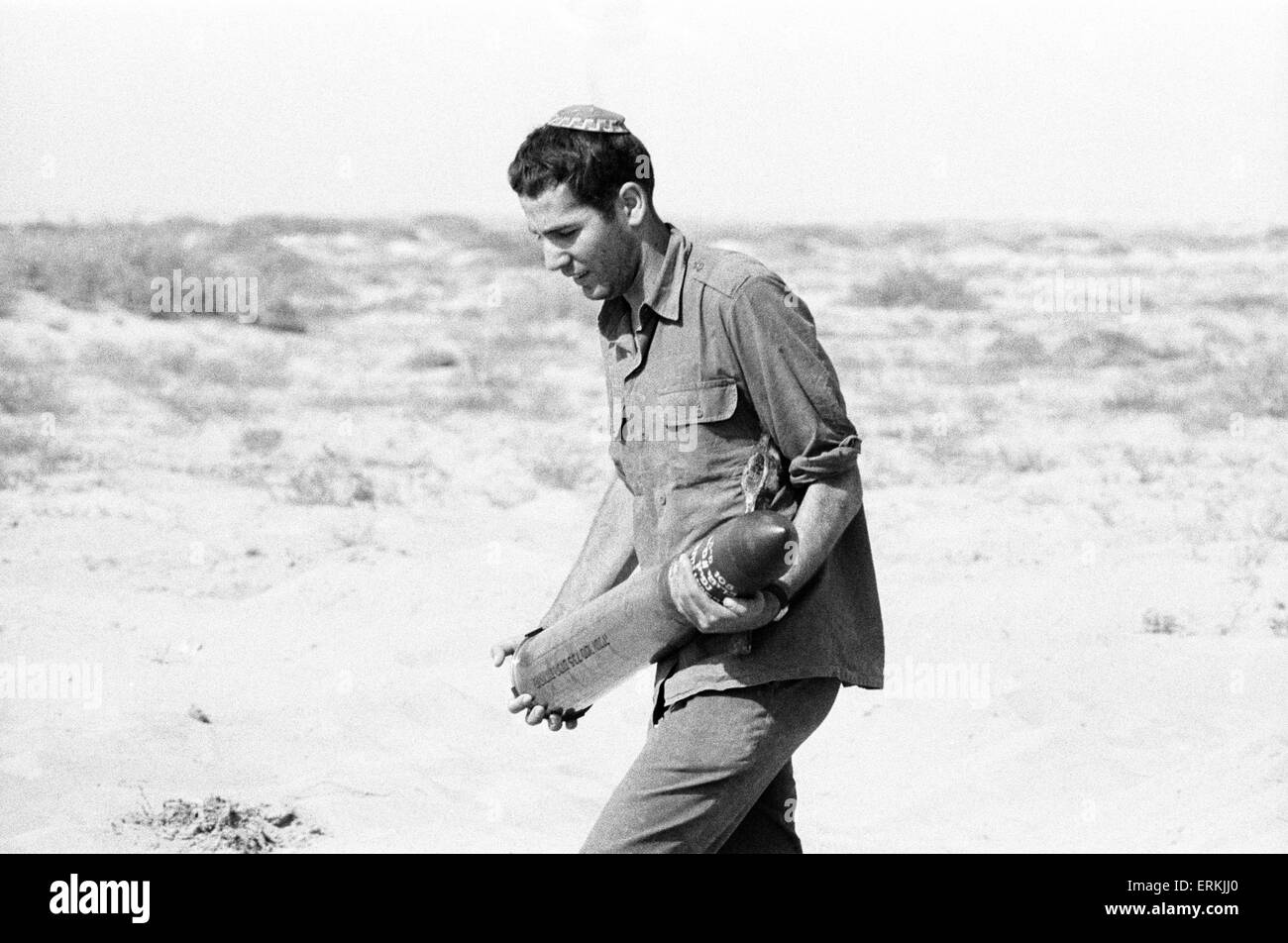 Yom Kippur War. The Fourth Arab Israeli War. October 6th to 25th, 1973. Israeli Soldier wearing Skullcap, carries artillery shell for tank. Sinai Desert. 9th October 1973. Stock Photo
