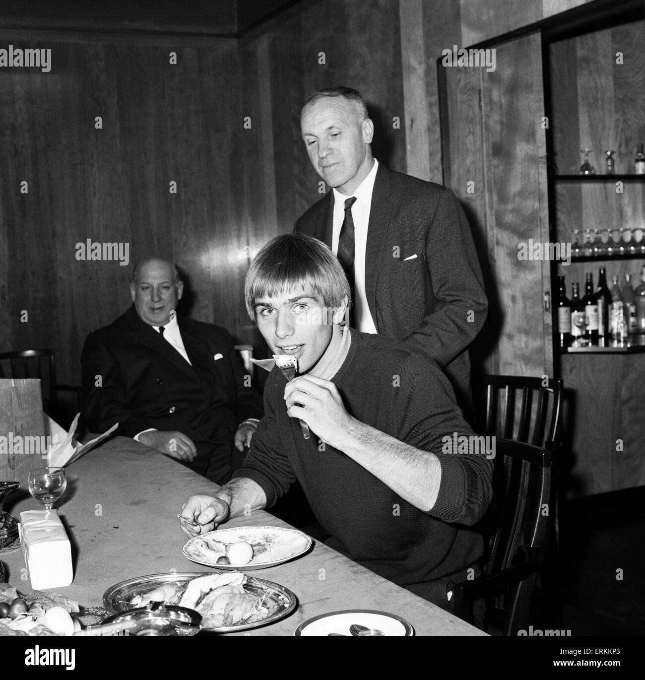 Alun Evans who became the first £100 000 teenager when signed for Liverpool from Wolverhampton Wanderers, enjoys a snack in the boardroom  watched by new manager Bill Shankly and chairman Sid Reakes after he signed. 16th September 1968. Stock Photo