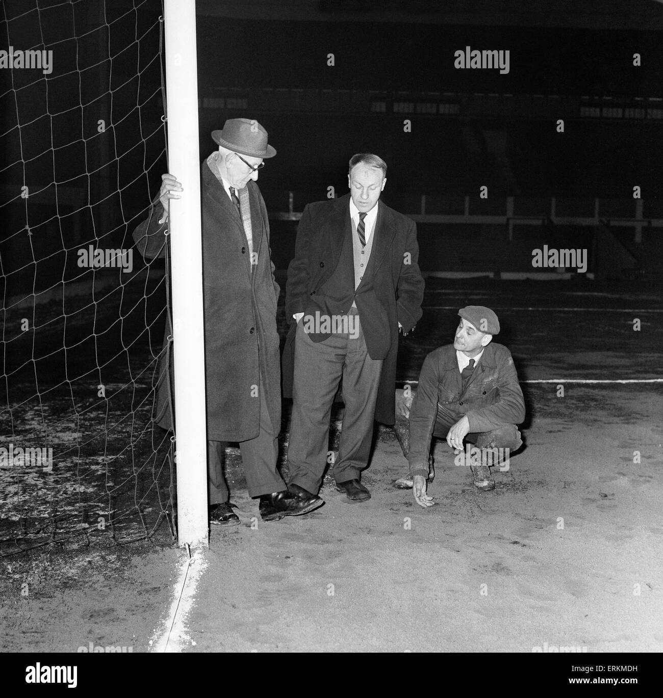 Liverpool manager Bill Shankly inspecting the Anfield pitch with chairman T V Williams and head groundsman Arthur Riley after referee  George McCabe called off the upcoming FA Cup fourth round replay match against Burnley at Anfield, only three hours before kick off, with Shankly having been assured the game was on. He criticised Harry Potts and claimed the Burnley manager 'seemed to be making it clear that he didn't want the game on' and added that he resented Potts appearance at Anfield for the pitch inspection. 11th February 1963. Stock Photo