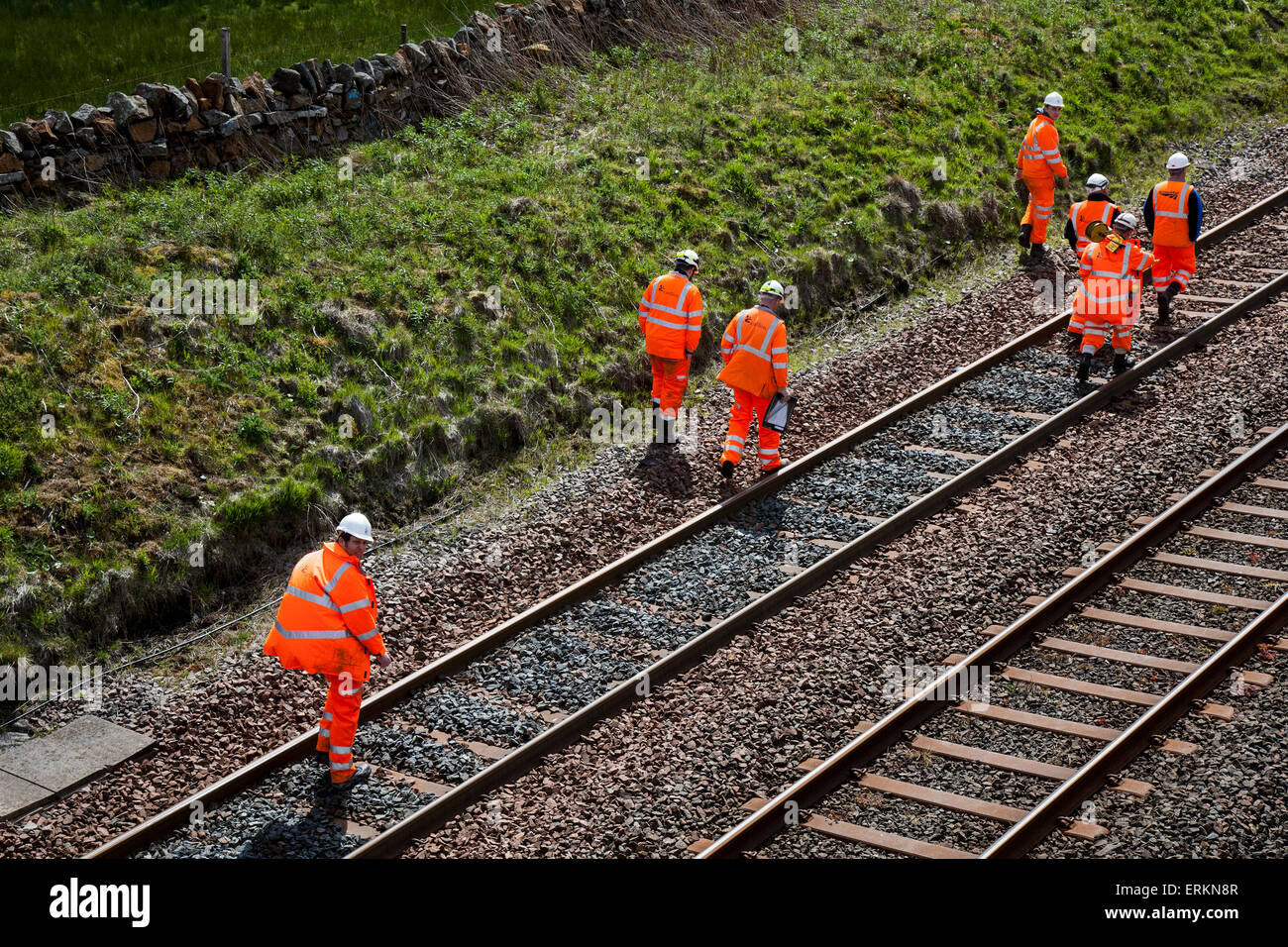 Network Rail Engineers & rail engineer on Settle Carlisle Line, Health and Safety for Men at Work. Tebay Cumbria working on rail track maintenance. Inspectors, Safety engineers, employees, rail workers, workmen, renewing railway lines and Infrastructure surveyors inspecting & measuring the transport freight line track at the summit of Ais Gill. The railway's summit at 1,169 feet (356 metres) is north of Garsdale is the highest mainline in England, and carries heavily loaded main line freight trains. Stock Photo