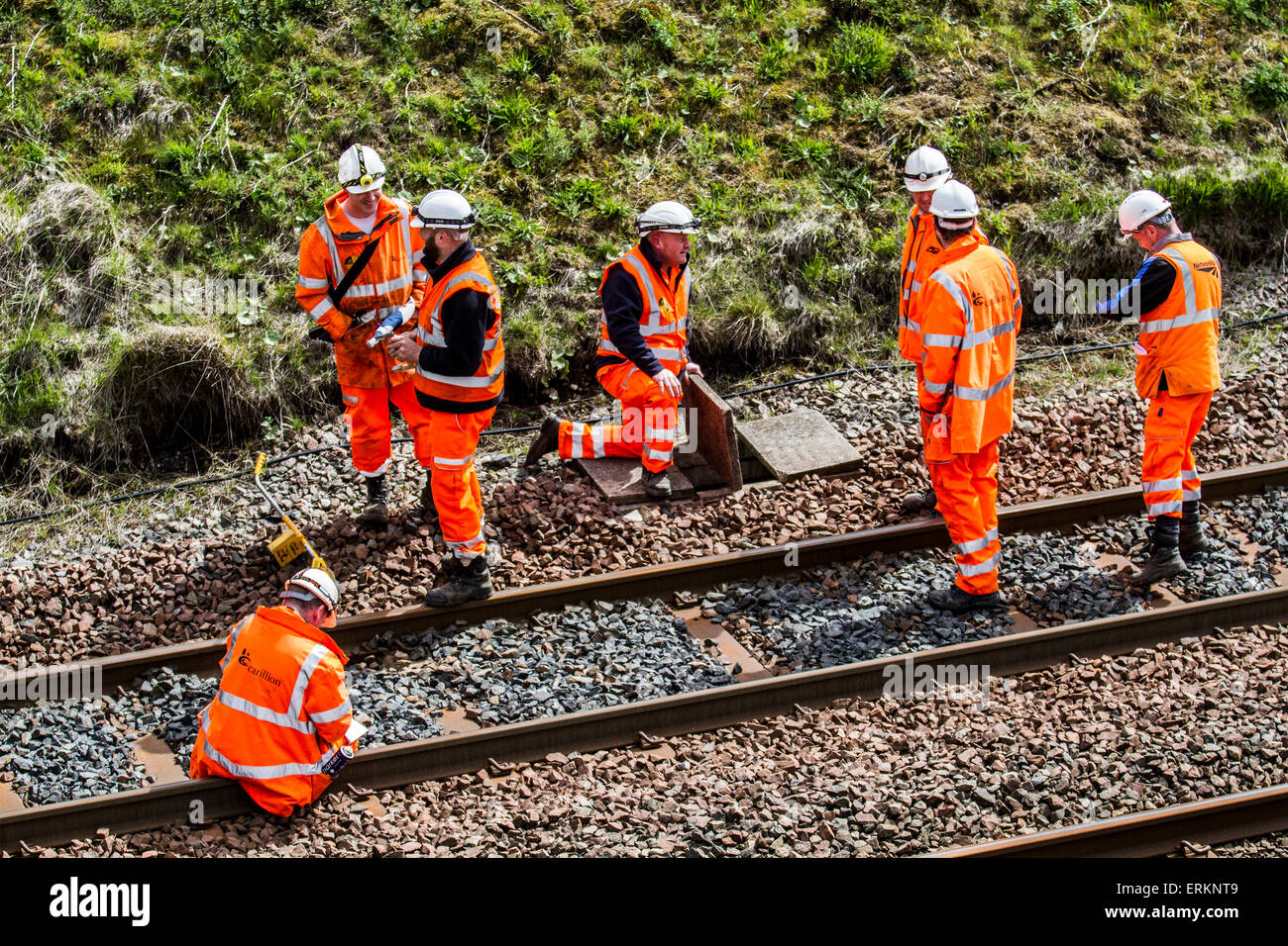 Tebay, Cumbria, UK 4th June, 2015. Health and Safety for Men at Work. Network Rail Engineers on Settle Carlisle Line, working on rail track maintenance. Inspectors, rail engineer. Safety engineers, employees, rail workers, workmen, renewing railway lines and Infrastructure surveyors inspecting & measuring the transport freight line track at the summit of Ais Gill. The railway's summit at 1,169 feet (356 metres) is north of Garsdale is the highest mainline in England,  and carries heavily loaded main line freight trains. Stock Photo