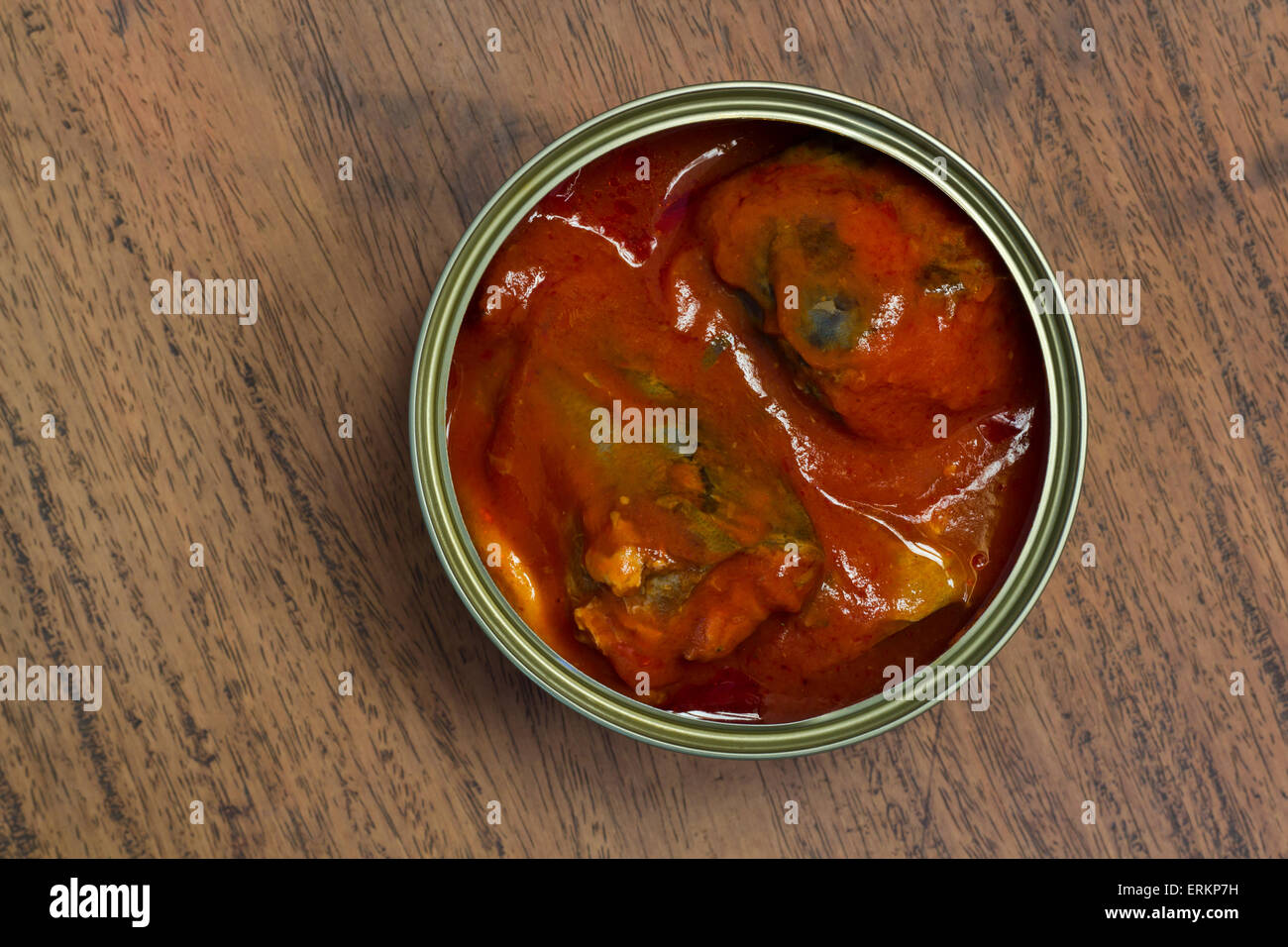 Uncovered Canned fish on wooden surface Stock Photo