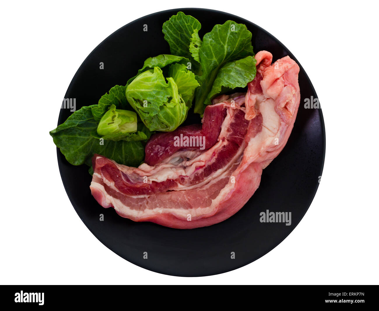 Raw streaky pork on black plate, isolated on white background and clipping path Stock Photo