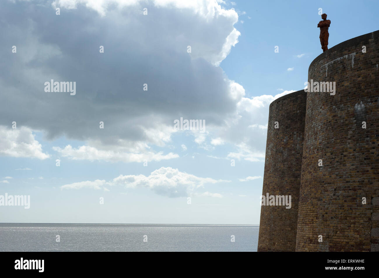 Antony Gormley's sculpture of a man looking out to sea, standing on the