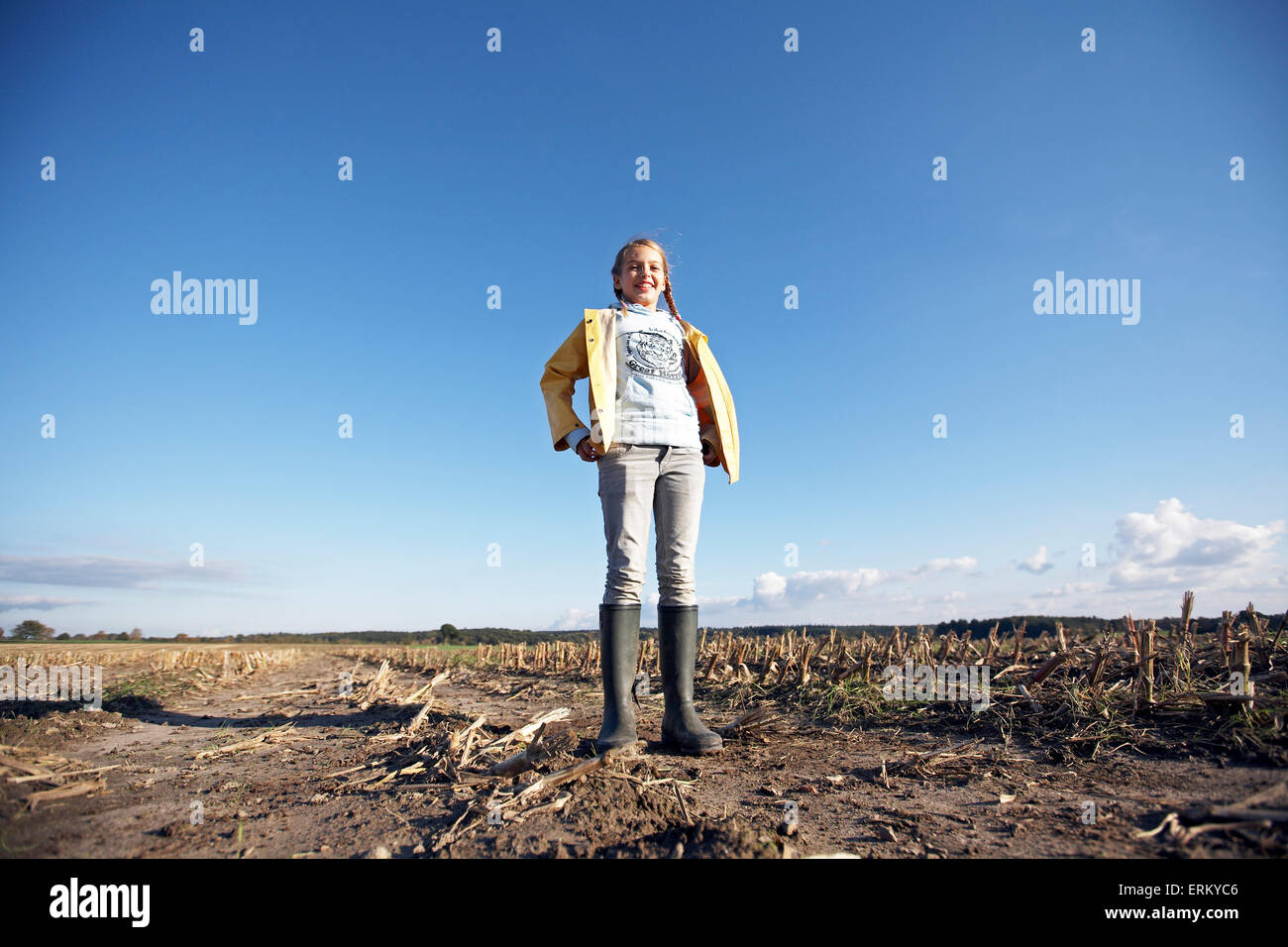 A young girl smiles with her hands on her hips in a field near Hamburg ...