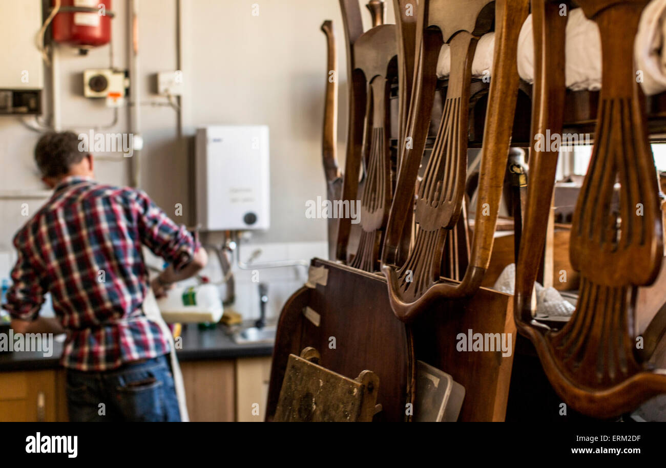 An antique furniture restorer's chairs piled on a workbench