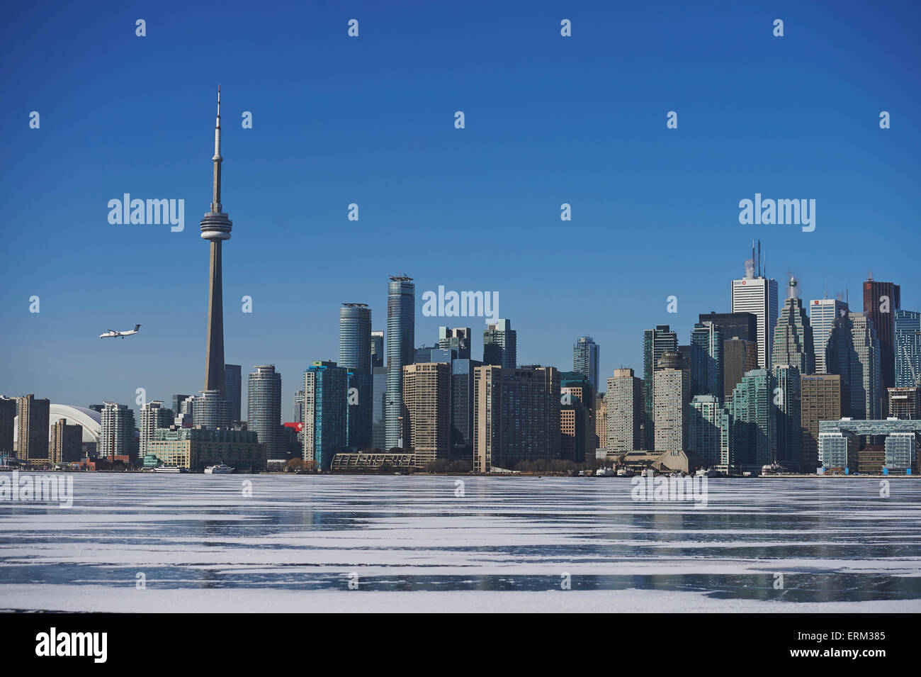 Airplane against city skyline in winter from Ward's Island; Toronto, Ontario, Canada Stock Photo