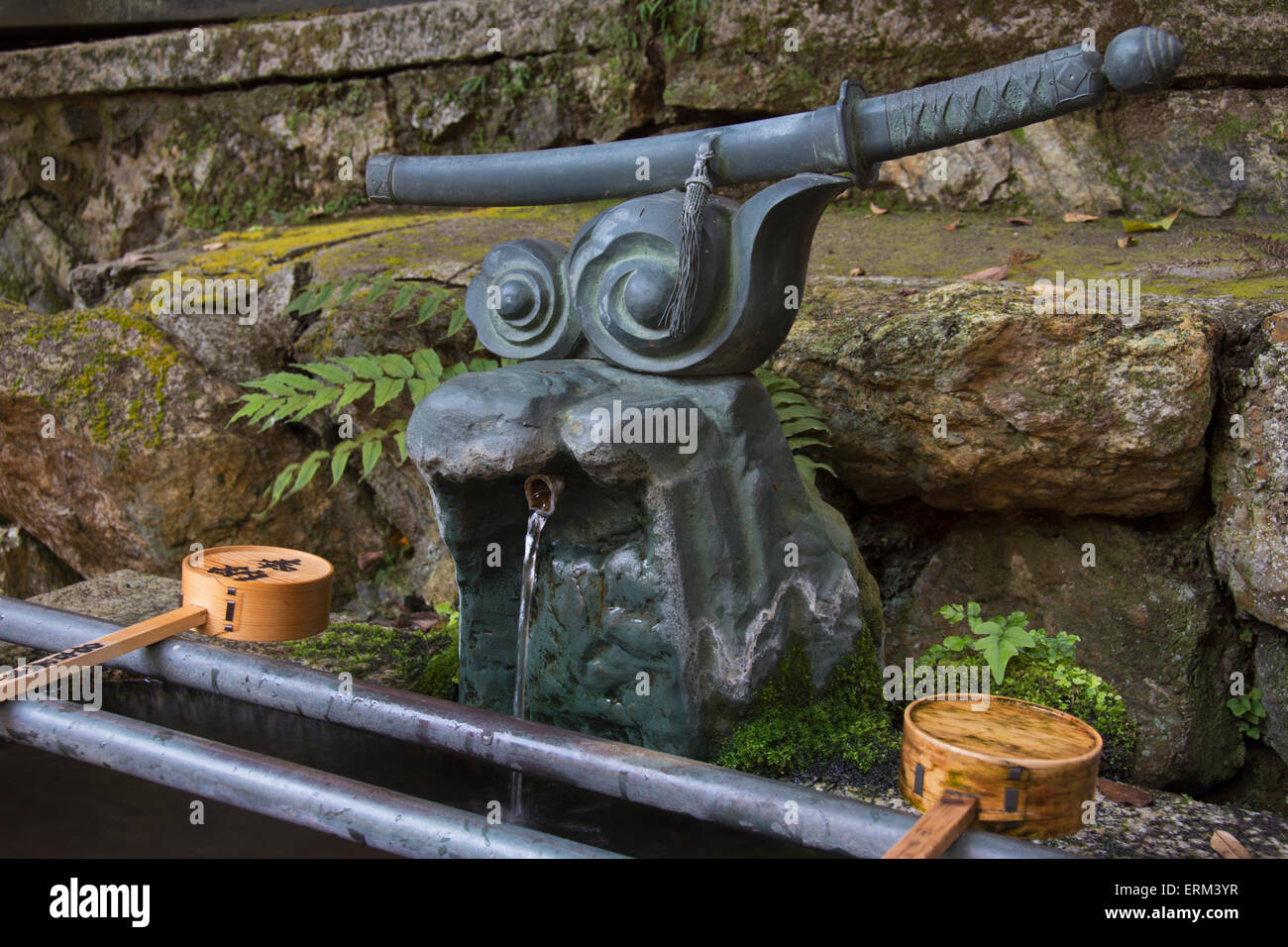Japanese shrine water fountain with samurai sword; Kyoto, Japan Stock Photo