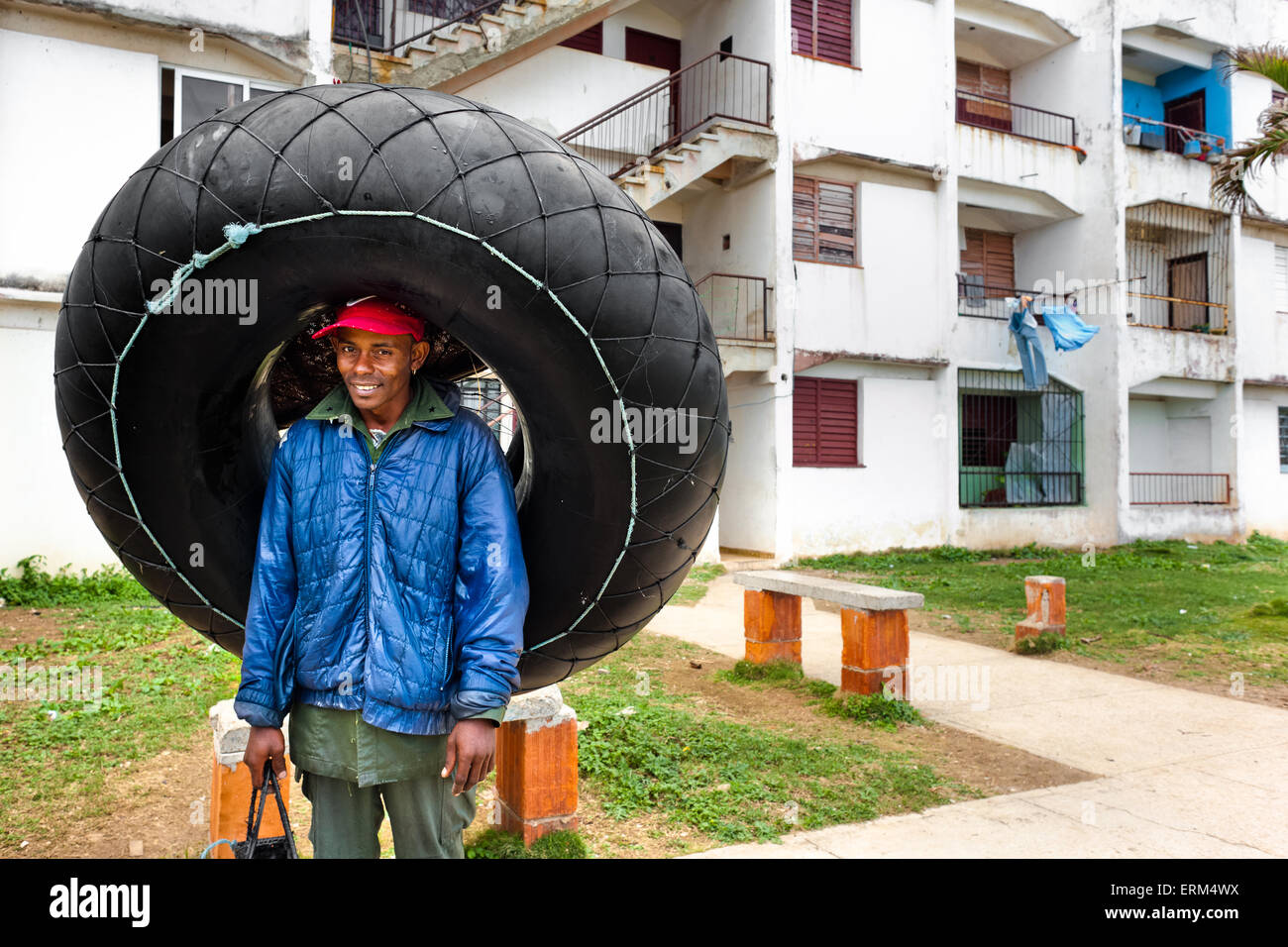 A young Cuban man holds a tire tube, used for fishing, close to the