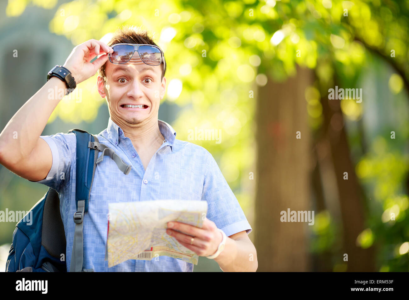 Young man with a map outdoors Stock Photo - Alamy