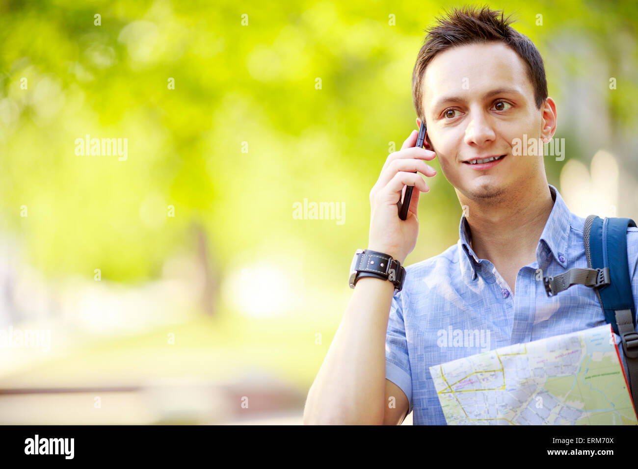 Man holding map outdoors and talking by phone Stock Photo