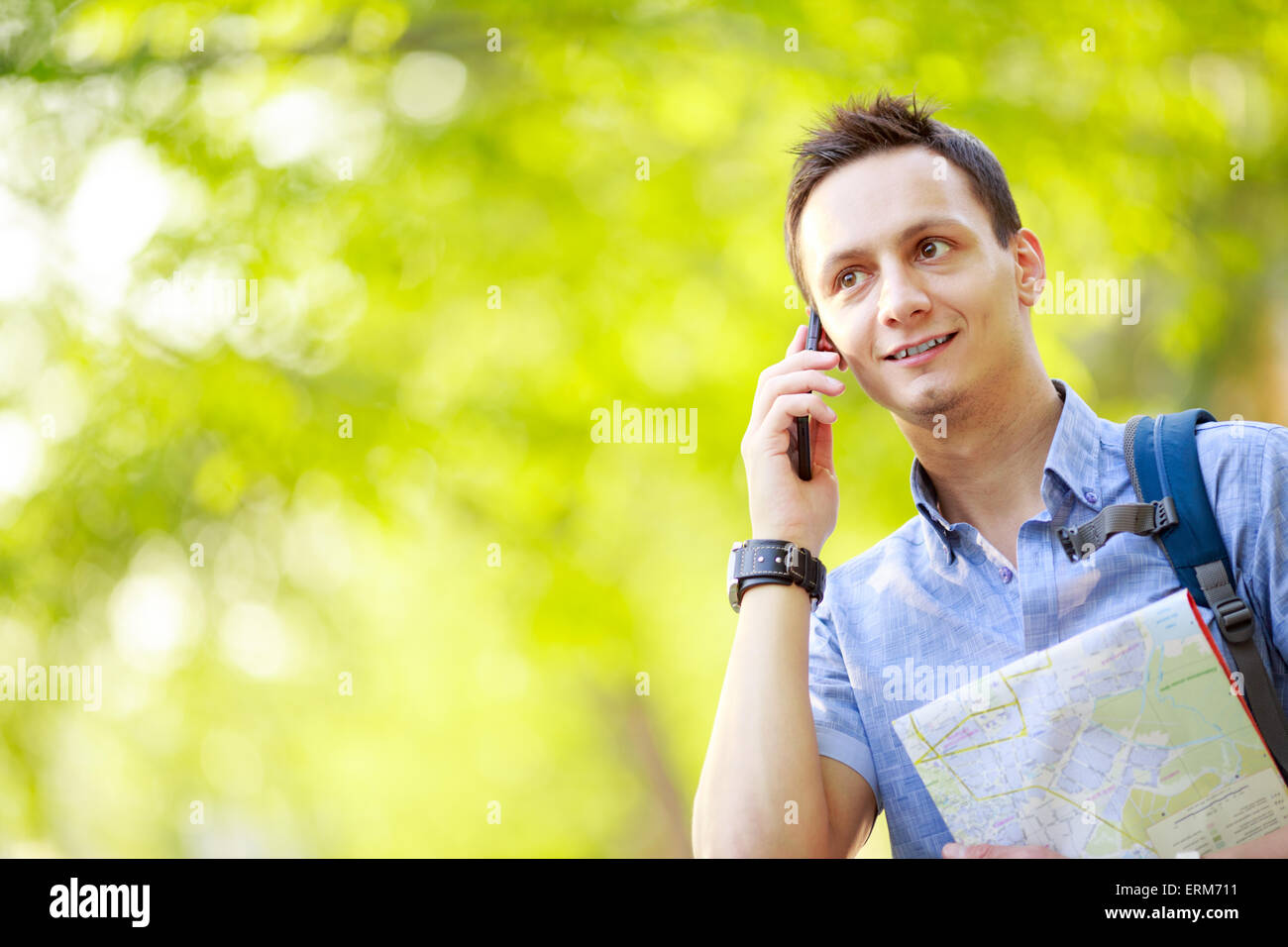 Man holding map outdoors and talking by phone Stock Photo