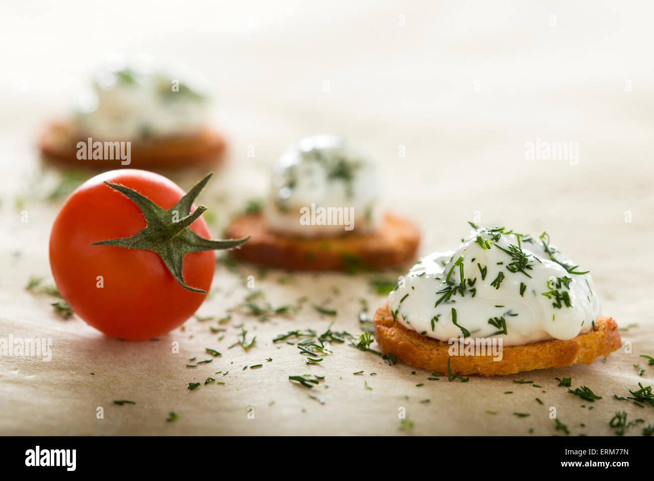 Fresh cream cheese spread with dill on bake rolls and cherry tomato