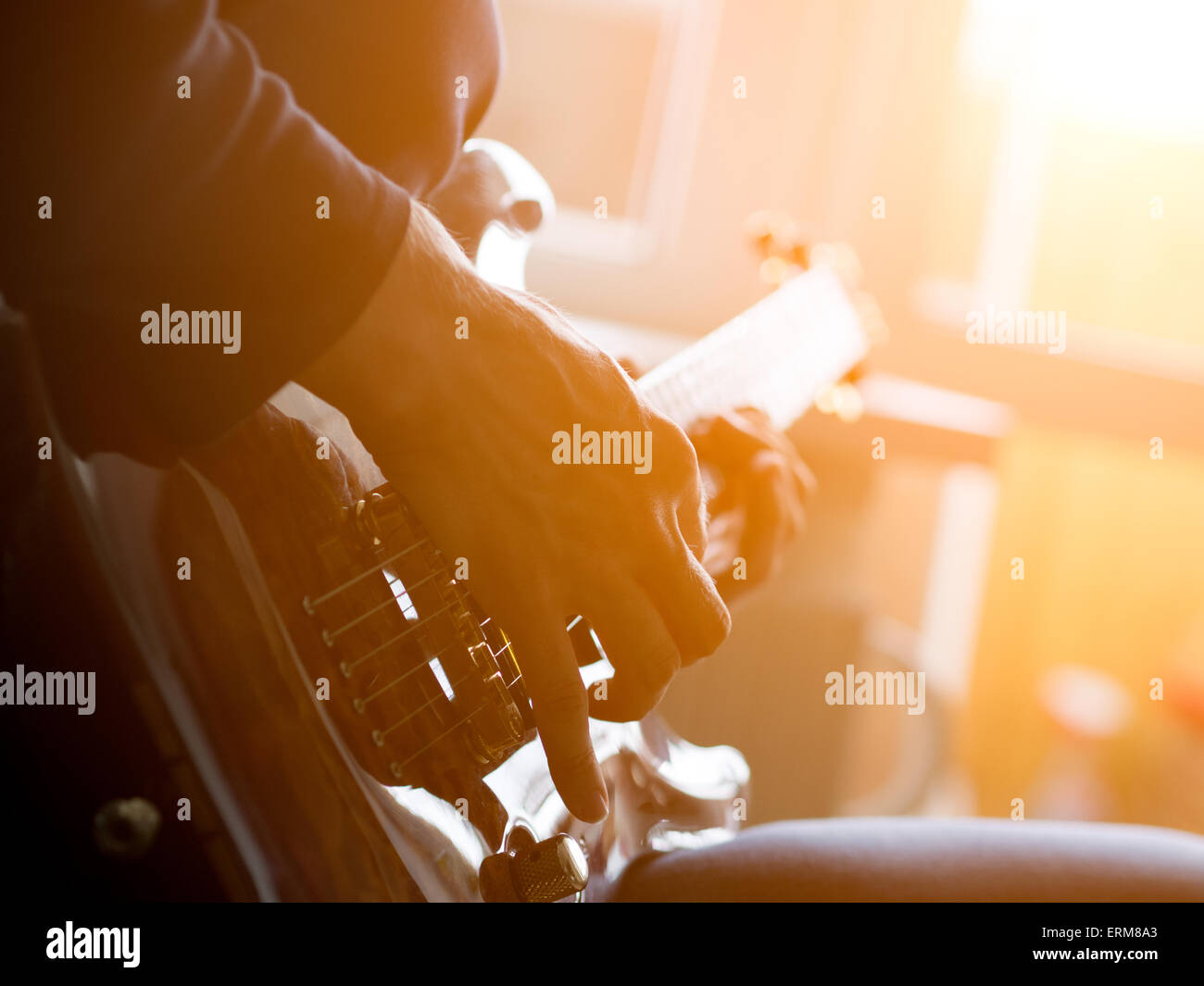 Male hand playing on acoustic guitar. Close-up. Stock Photo
