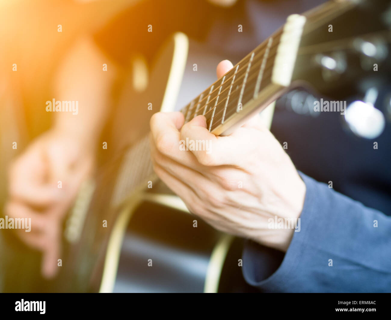 Male hand playing on acoustic guitar. Close-up. Stock Photo