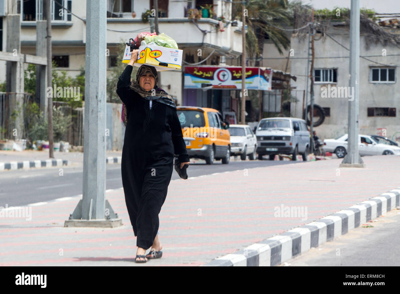 Gaza City, Palestinian Territories. 01st June, 2015. A woman carries her shopping in the district Shujjaiya in Gaza City, Palestinian Territories, 01 June 2015. The citizens of the the extremely densely populated Palestinian Territories still suffer from the consequences of the latest war with more than 2,200 fatalities. Photo: JENS BUETTNER/dpa/Alamy Live News Stock Photo