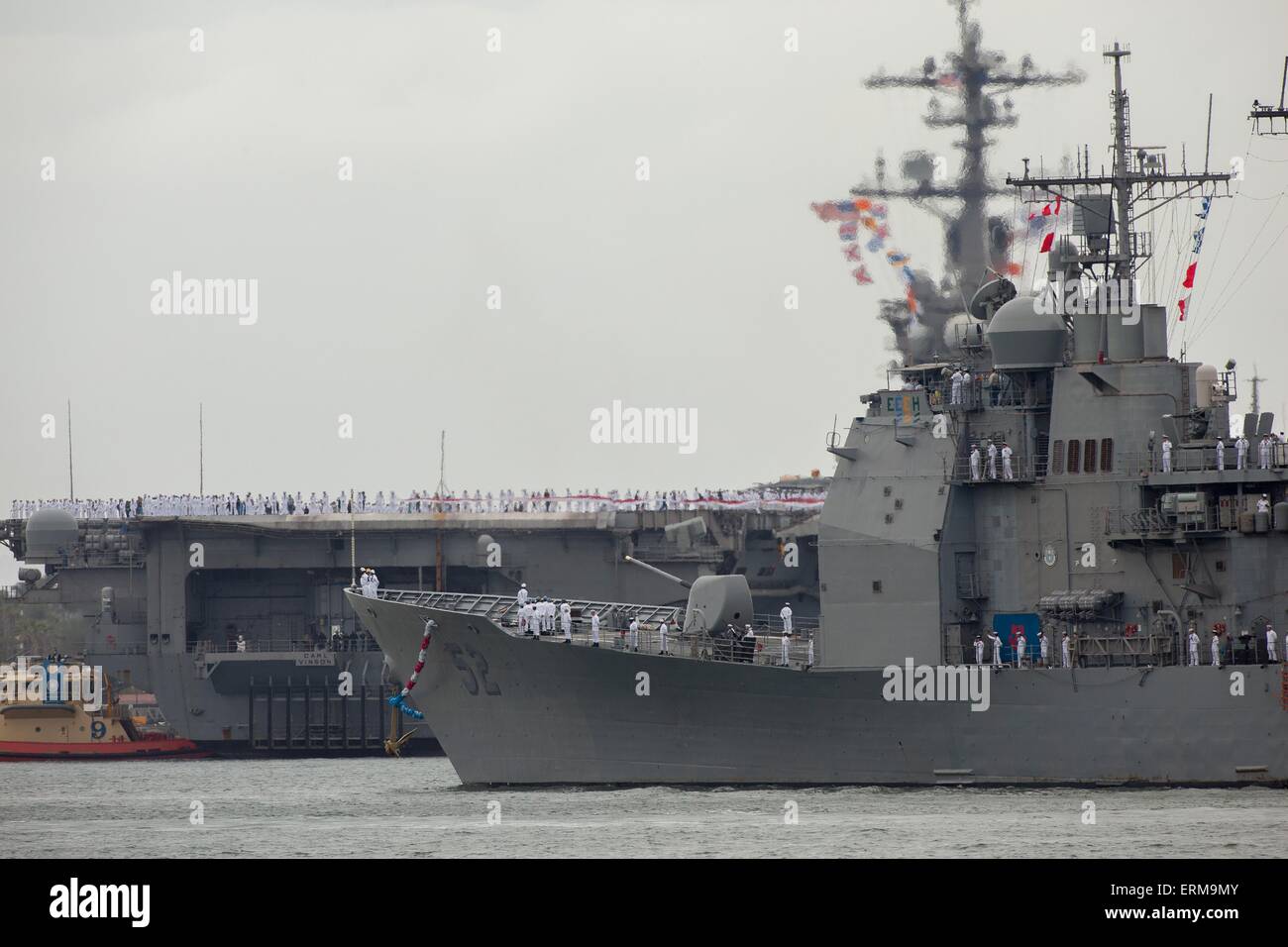Coronado, CA, US. 4th June, 2015. USS Carl Vinson(CVN 70) Carrier Strike Group Comes Home. The Carl Vinson Strike Group returns to the San Diego area after a nearly 10-month deployment to U.S. 5th Fleet and 7th Fleet that included six months of strikes against the Islamic State.Seen here: Guided-missile cruiser USS Bunker Hill (CG-52) in foreground with the Carl Vinson docking. © Daren Fentiman/ZUMA Wire/Alamy Live News Stock Photo