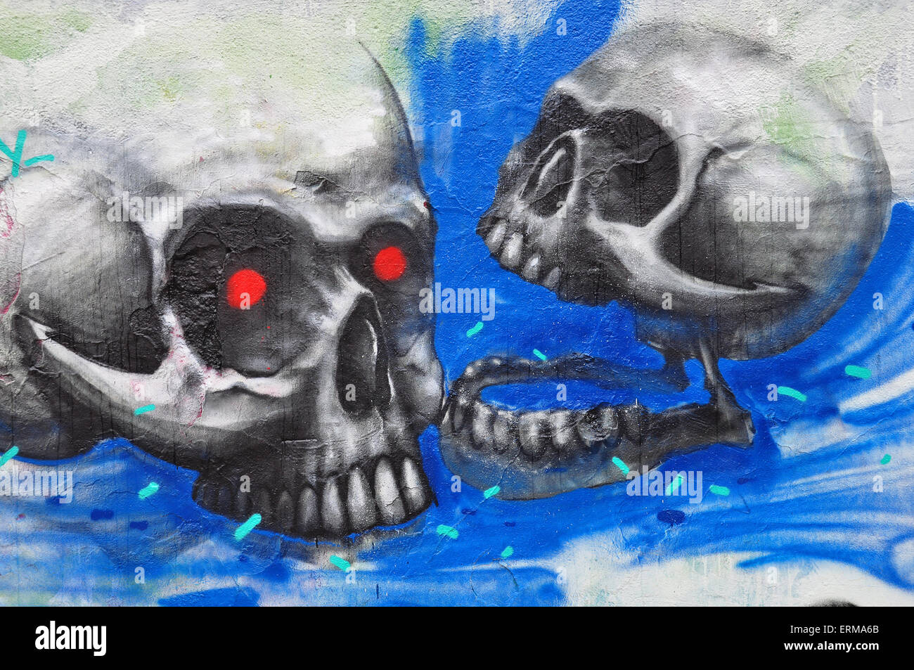 Two zombie skulls on textured wall abstract graffiti urban art. Stock Photo