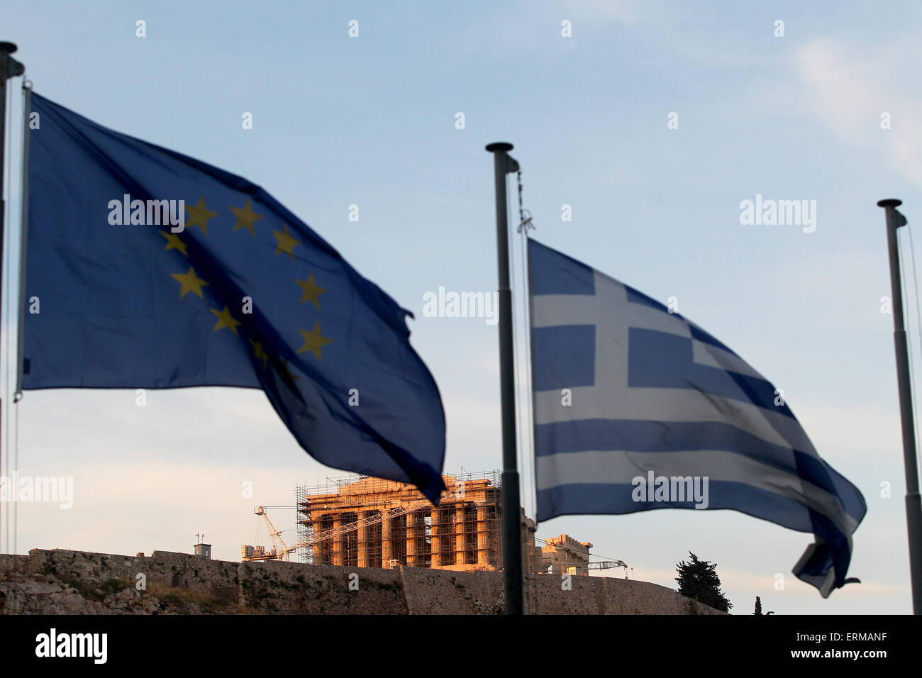 Athens, Greece. 4th June, 2015. Greek and European Union flags fly while the sun sets over the Acropolis, in Athens, Greece, on June 4, 2015. The Greek government on Thursday expressed optimism over a 'mutually acceptable' deal with international creditors on the country's debt repayment arrangements following the latest inconclusive talks in Brussels. © Marios Lolos/Xinhua/Alamy Live News Stock Photo