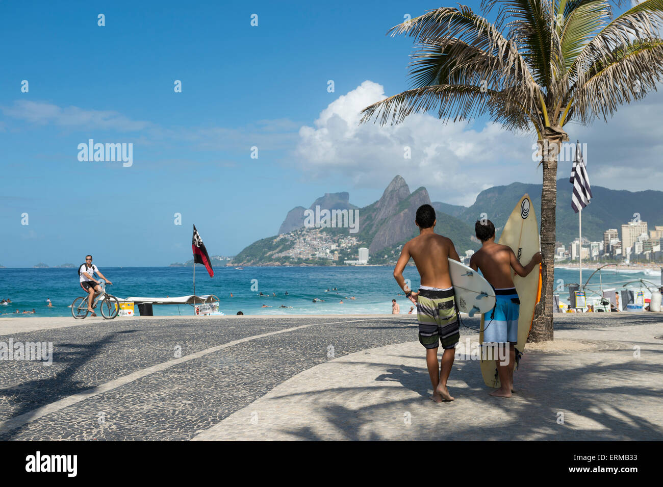 RIO DE JANEIRO, BRAZIL - FEBRUARY 21, 2015: Pair of young Brazilians stand with surfboards at the popular surf point at Arpoador Stock Photo