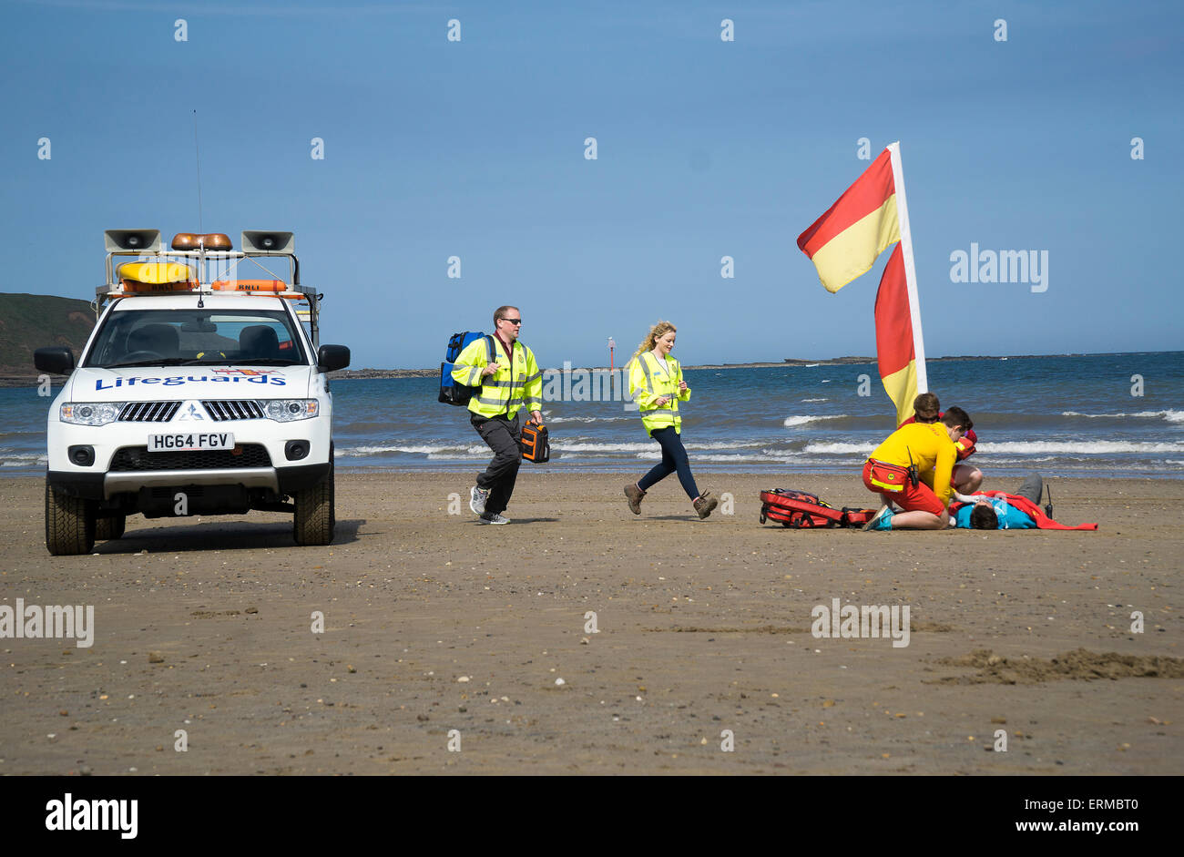 Rnli and paramedic first responers treat casualty on the beach Stock Photo