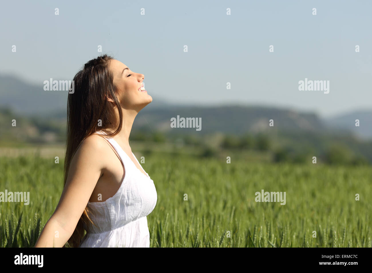 Girl breathing fresh air with white dress in a green wheat meadow Stock ...