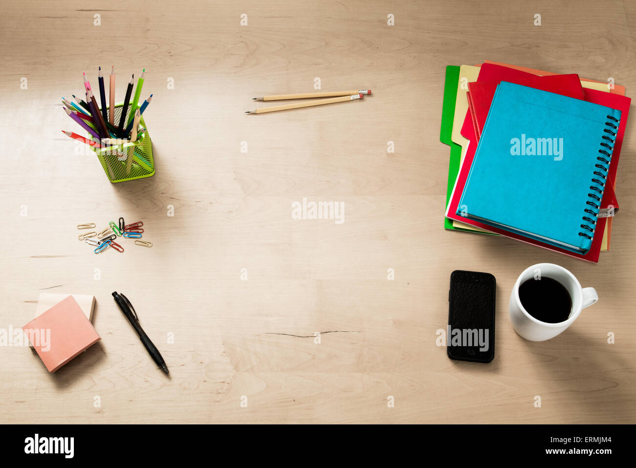 Modern creative workspace made of a flat wooden table, color pencils, coffee a smartphone and other objects Stock Photo