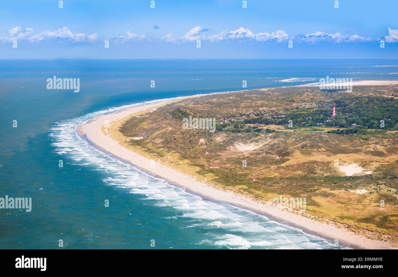 Aerial view of sand dunes and beach with red and white lighthouse in Zeeland, Netherlands, taken from above on helicopter trip Stock Photo
