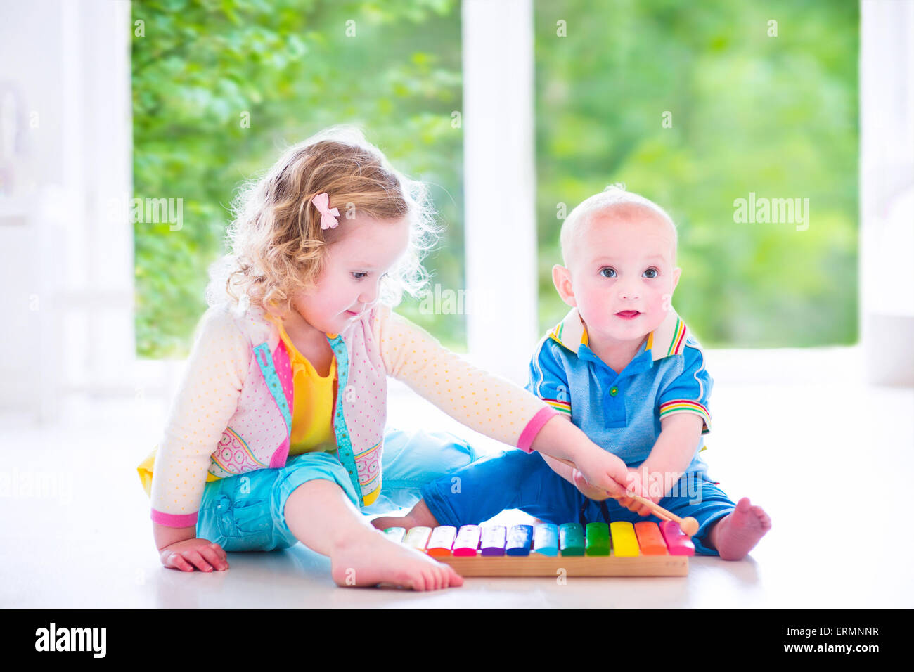 Two little children cute curly toddler girl and a funny baby boy