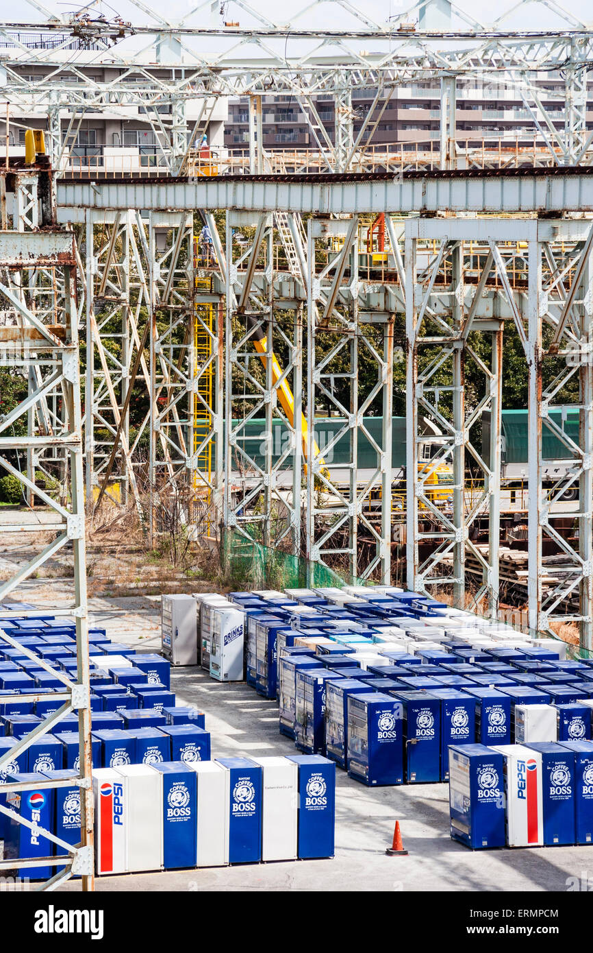Old blue Suntory Boss Coffee vending machines stacked in rows outdoors