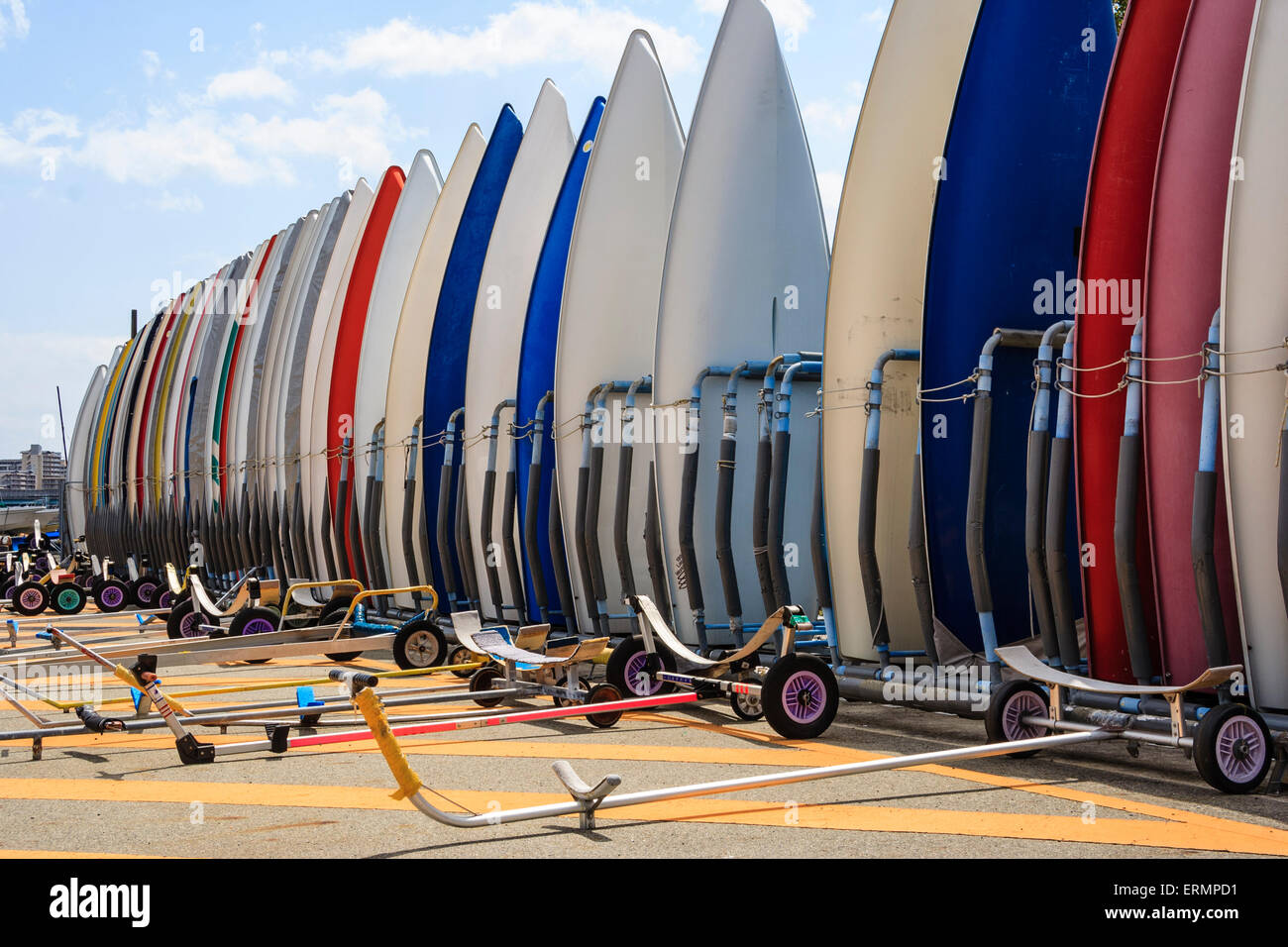 View along a row of laser dinghies, hulls, stacked tightly together on