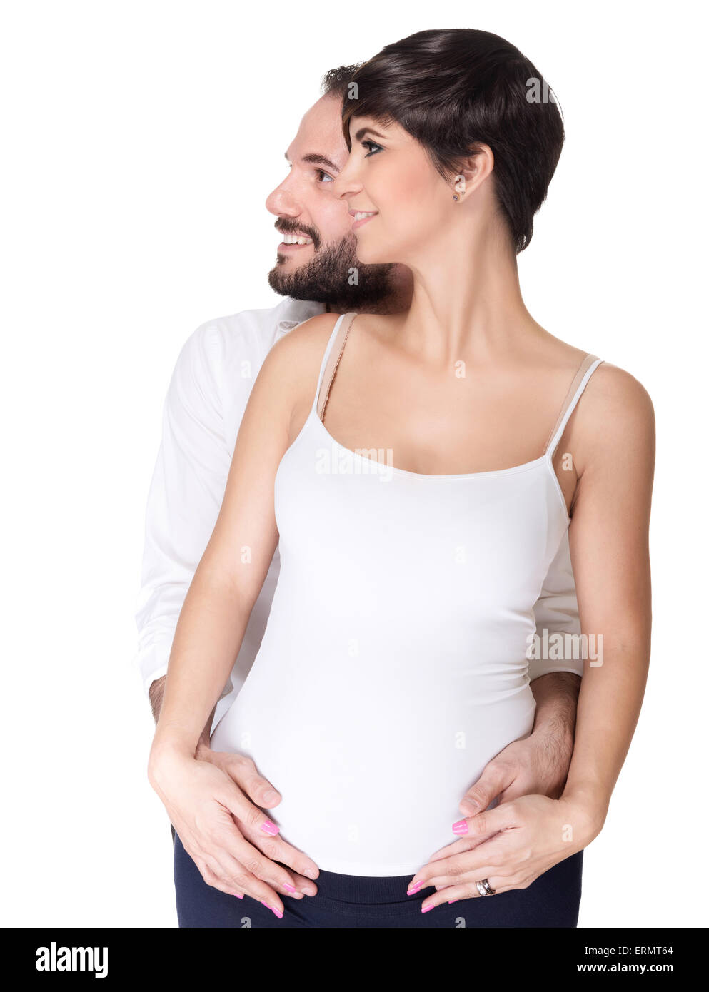 Portrait of beautiful couple waiting baby posing in the studio, looking in side isolated on white background, happy young family Stock Photo