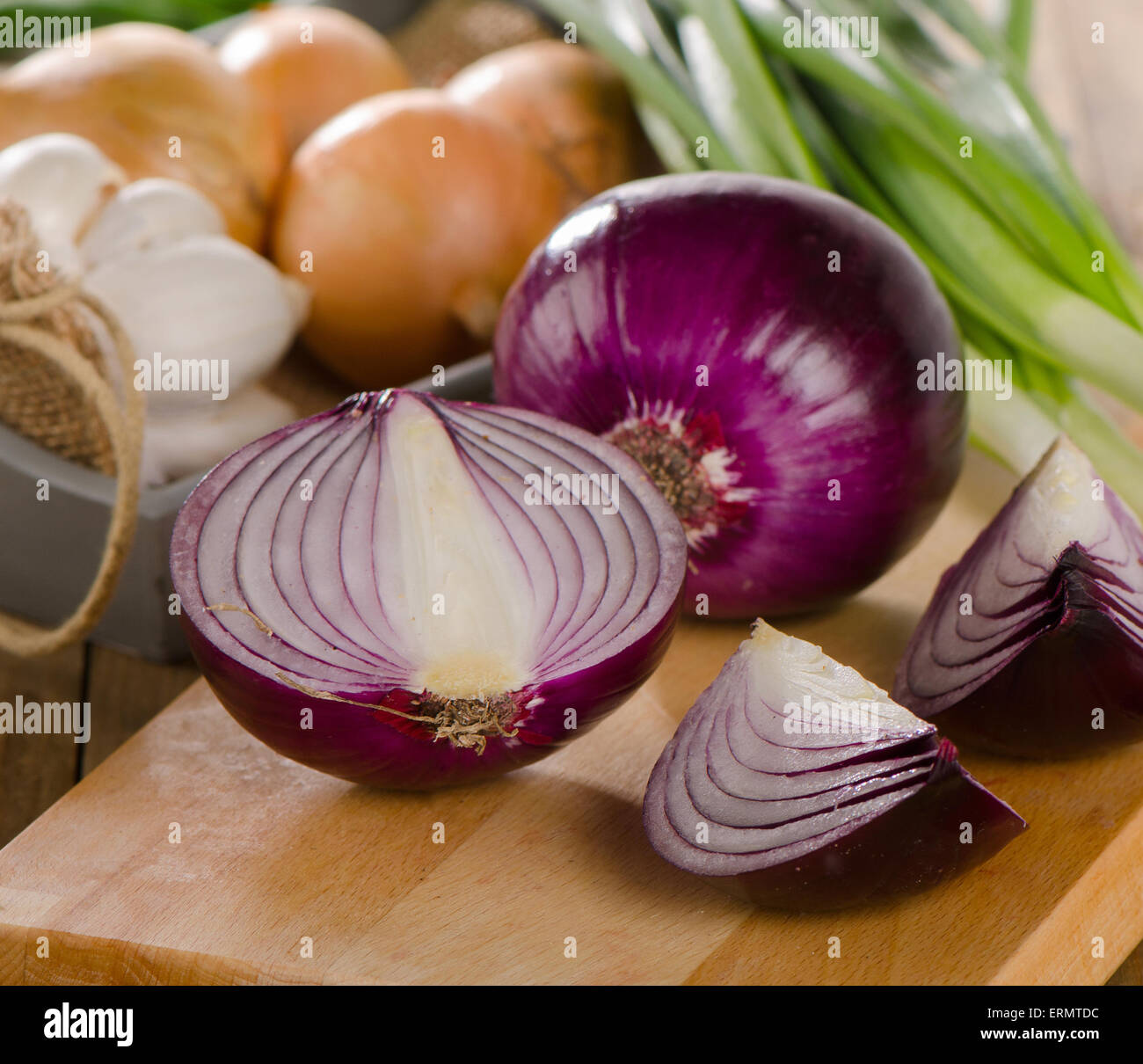 Different fresh onions on wooden cutting board Stock Photo - Alamy