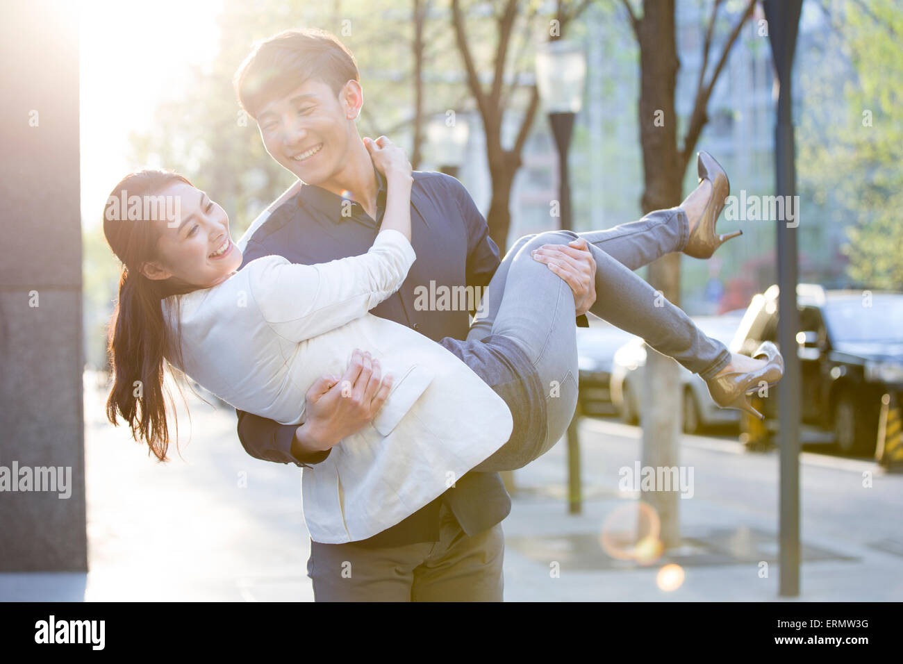 Young man carrying girlfriend in arms Stock Photo Alamy