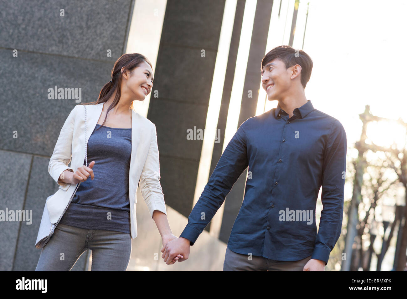 Young couple holding hands walking Stock Photo - Alamy